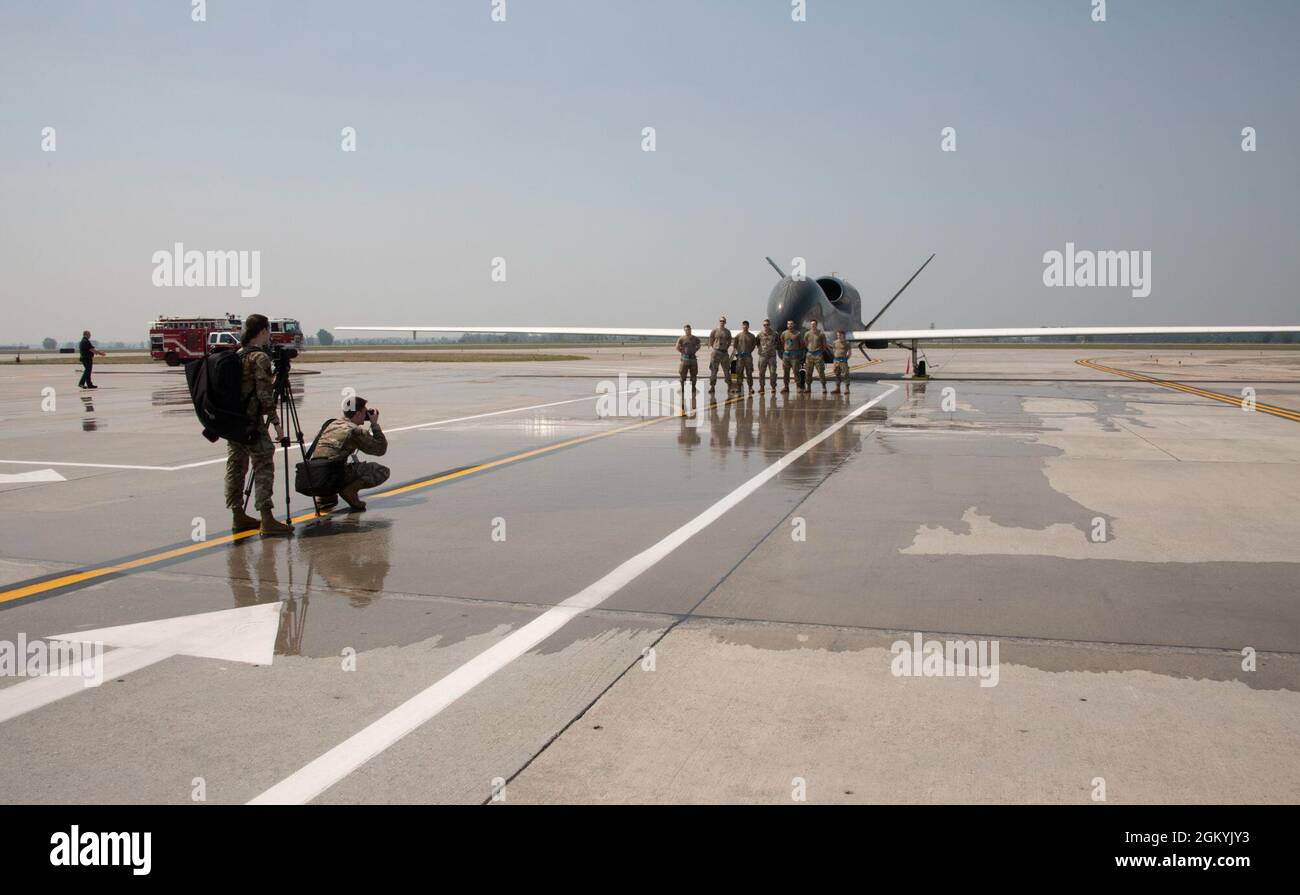 Gli airman del 348° Squadrone della rinascita posano per una foto di fronte a un falco globale EQ-4 dopo il suo atterraggio finale alla base dell'aeronautica di Grand Forks, N.D., luglio 29. 2021. L’EQ-4, denominato anche “blocco 20”, ha servito da colonna portante del programma Global Hawk presso la Grand Forks AFB dal 2011. Foto Stock