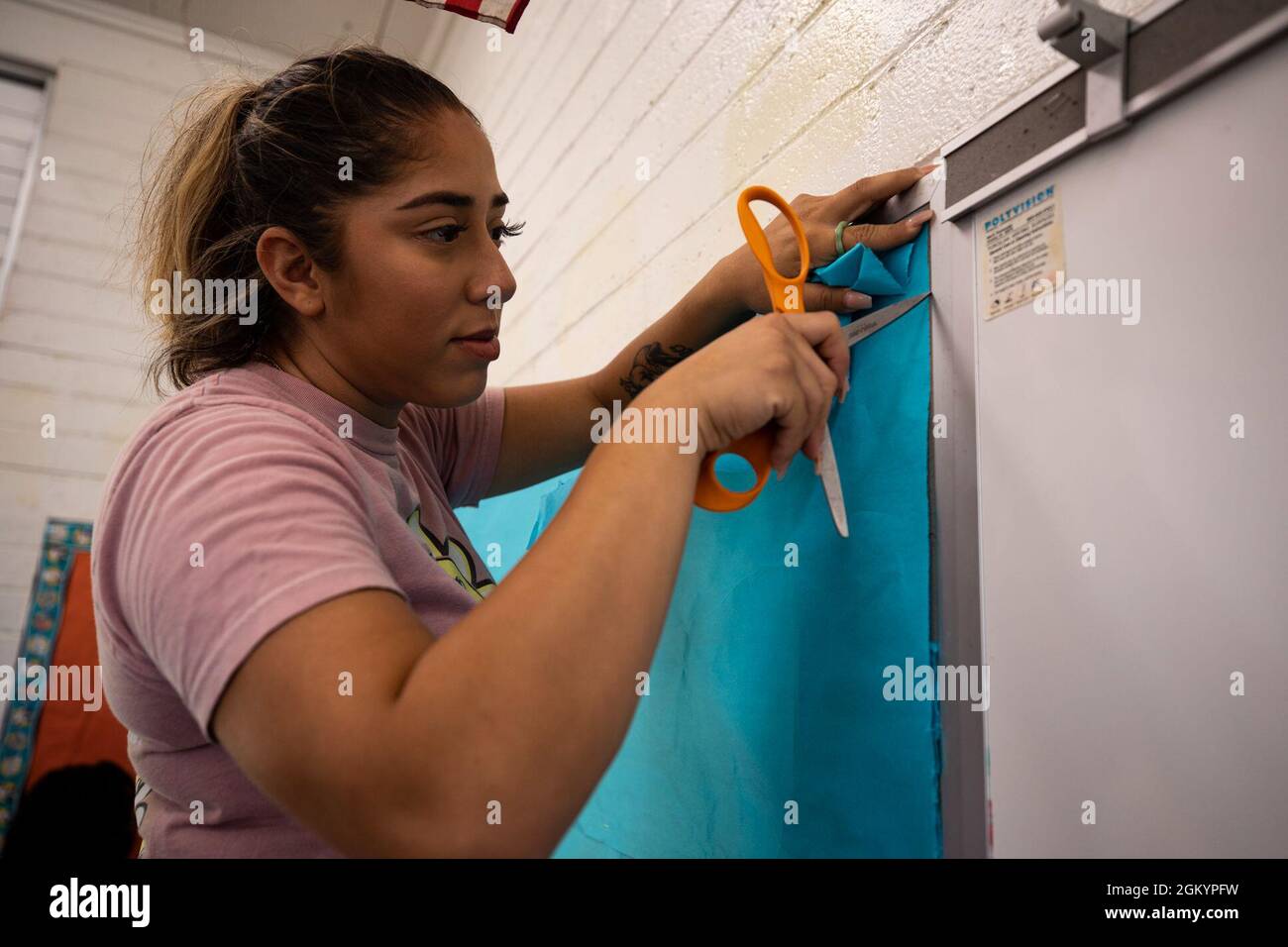 CPL del corpo marino degli Stati Uniti. Klarissa Lopez, impiegato della società di assistenza, sede di Battaglione, base del corpo Marino Hawaii, taglia la carta da poster durante un evento volontario alla scuola elementare di Kailua, Hawaii, 30 luglio 2021. La risorsa più importante di MCBH è la gente, la collaborazione e il supporto della comunità locale sono tra le priorità principali dell'installazione. Foto Stock