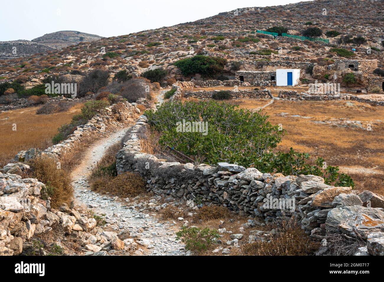Percorso che conduce al faro di Aspropoumta sull'isola greca di Folegandros oltre gli edifici agricoli Foto Stock