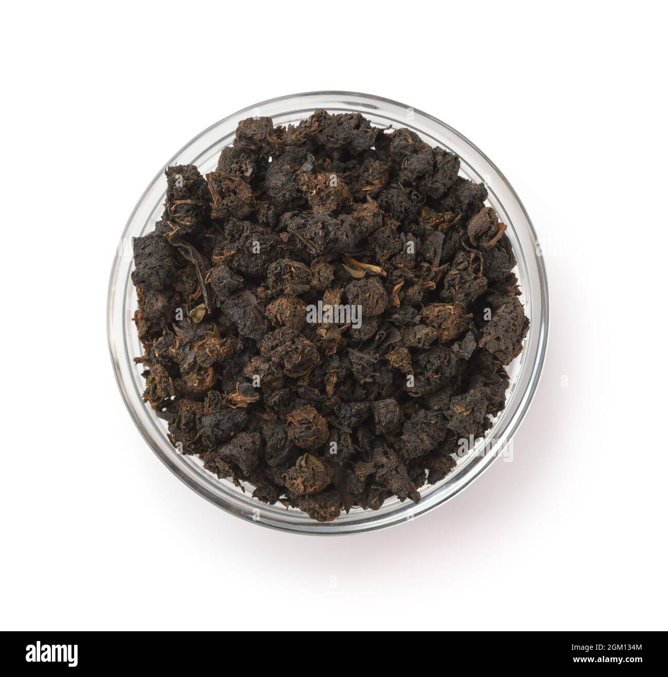 Vista dall'alto del tè nero granulare in un recipiente di vetro isolato su bianco Foto Stock