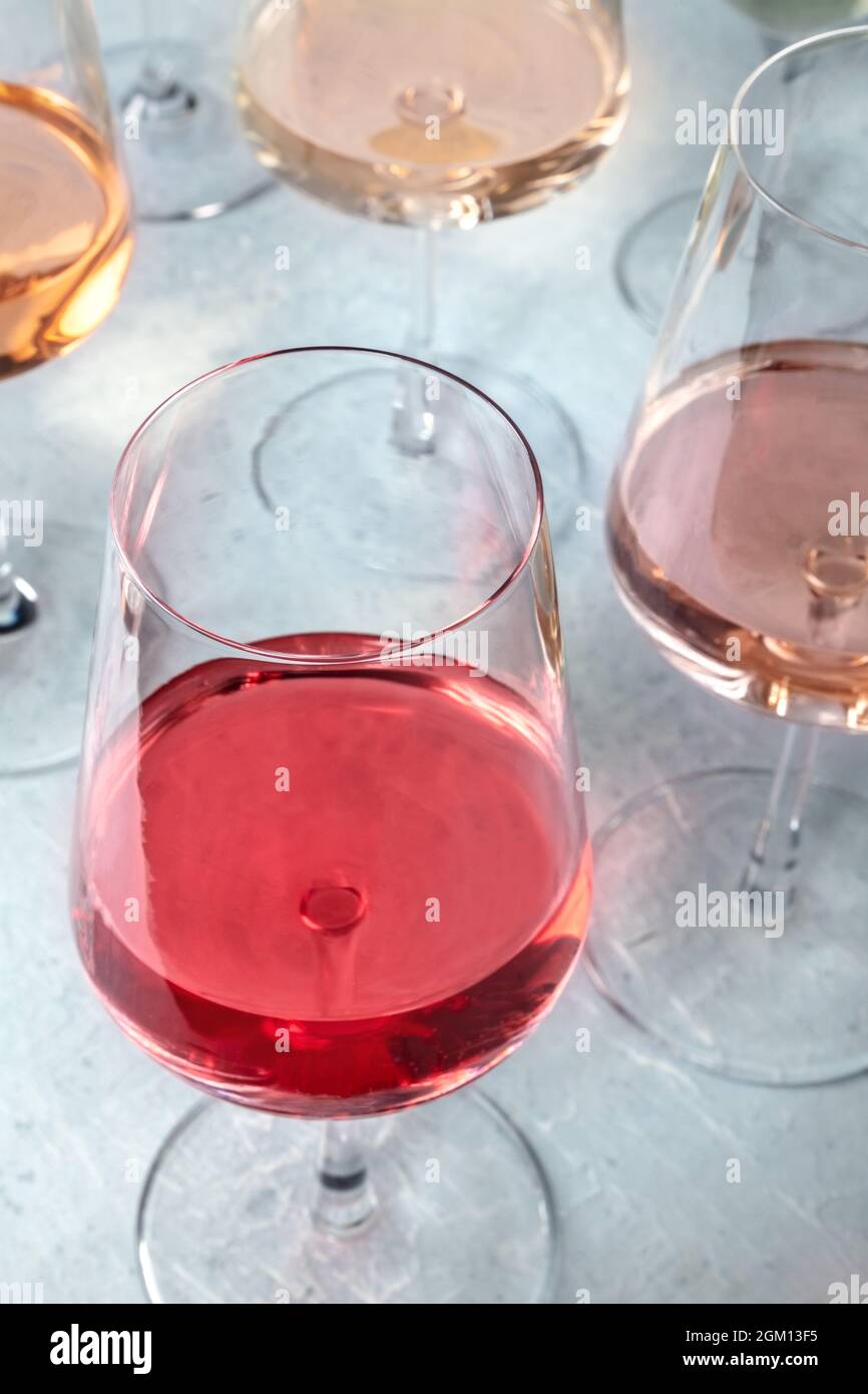 Vino rosato di varie sfumature in una degustazione in una cantina. Evento di degustazione vini. Eneglasses elegante Foto Stock