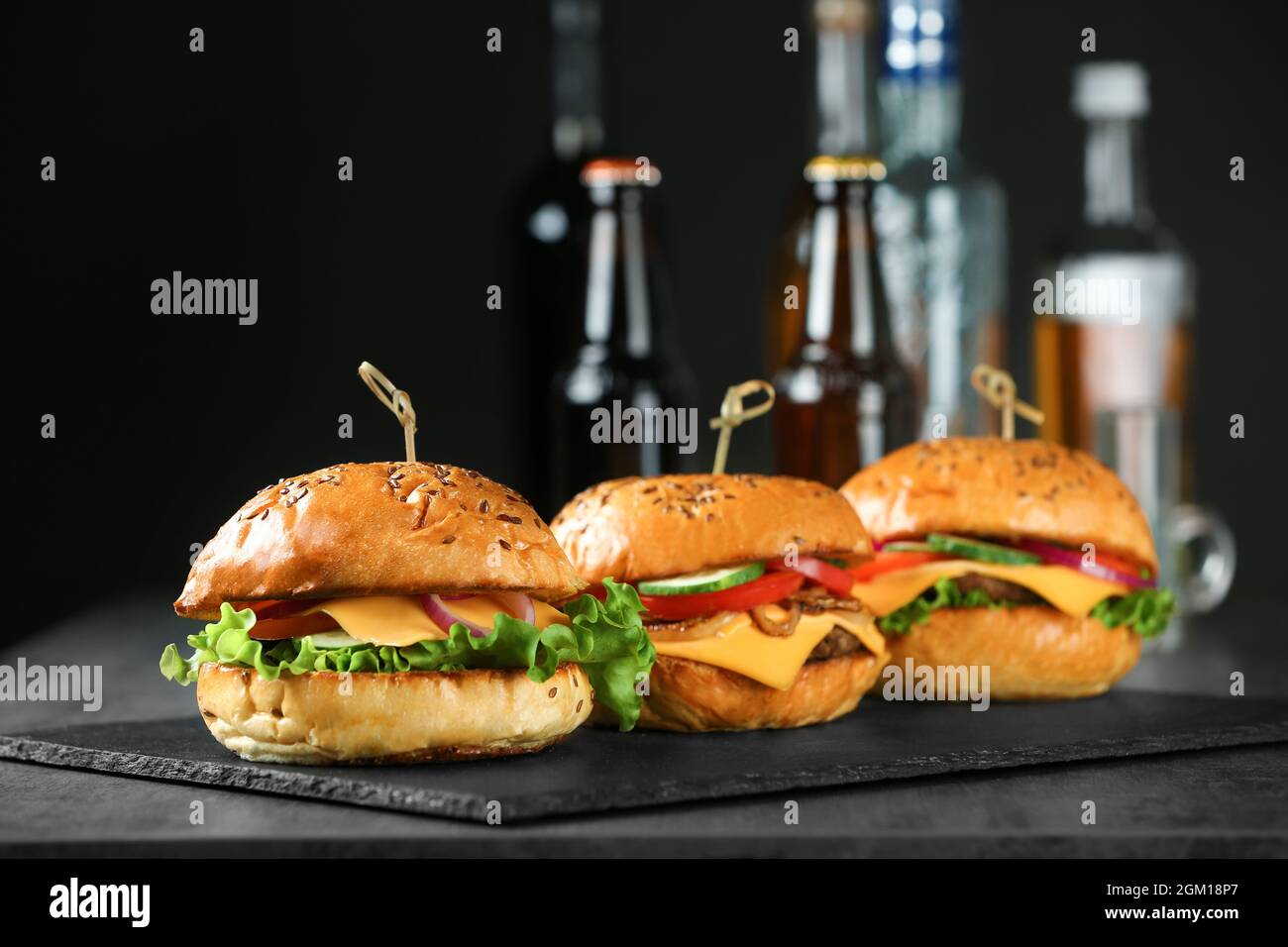 Piastra di ardesia con gustosi hamburger sul tavolo Foto stock - Alamy