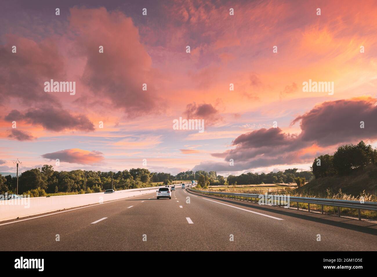 movimento dei veicoli in autostrada, autostrada durante il tramonto Foto Stock