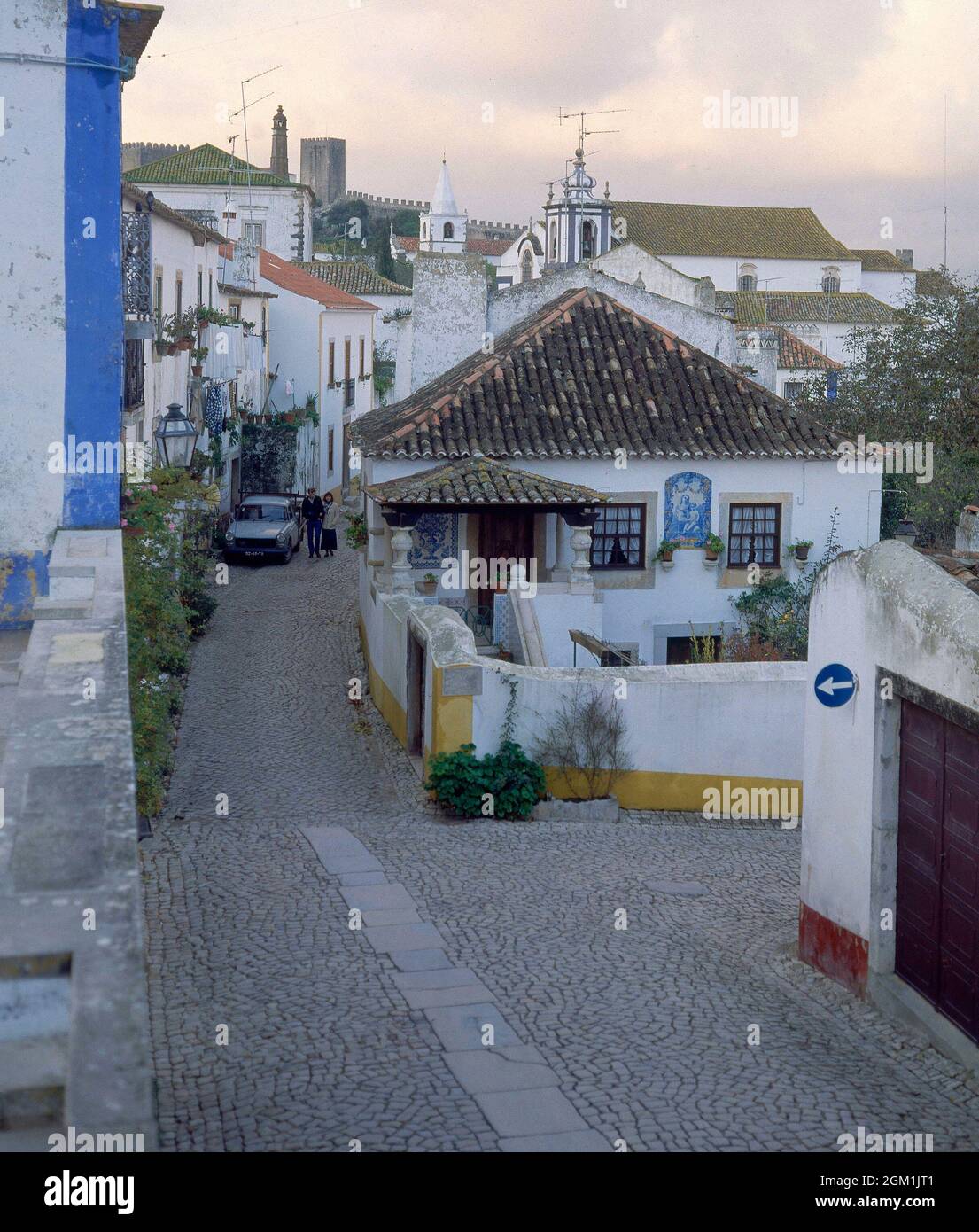 CALLE EMPEDRADA - CASAS BLANCAS CON LOS BORDES PINTADOS DE COLORES. Ubicazione: ESTERNO. OBIDOS. PORTOGALLO. Foto Stock