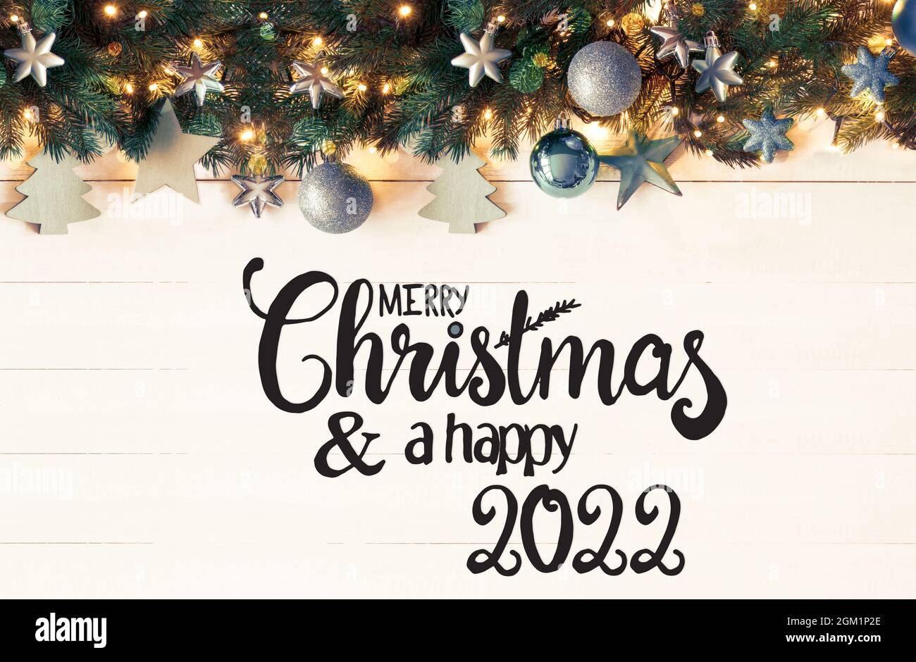 Inglese Calligraphy buon Natale e un felice 2022. Banner retrò natalizio  con decorazione natalizia turchese e rami di abete con luci fairy Foto  stock - Alamy