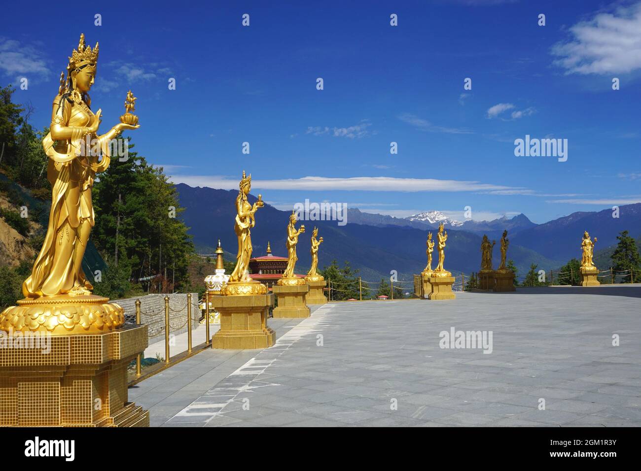 Le graziose statue dorate della dea fiancheggiano la terrazza superiore intorno alla statua di Buddha Dordenma nel parco naturale Kuensel Phodrang vicino Thimphu, Bhutan. Foto Stock