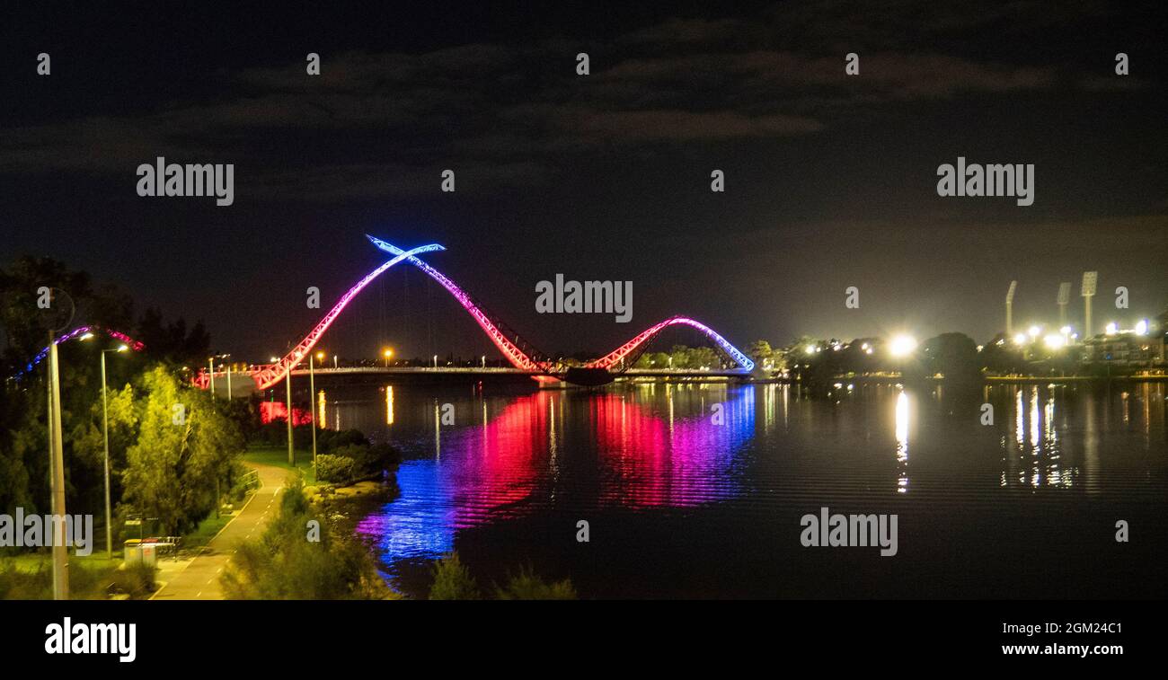 Ponte pedonale sospeso Matagarup Bridge sul fiume Swan illuminato nei colori del Melbourne Football Club dopo 2021 AFL Preliminary Final Perth WA Foto Stock
