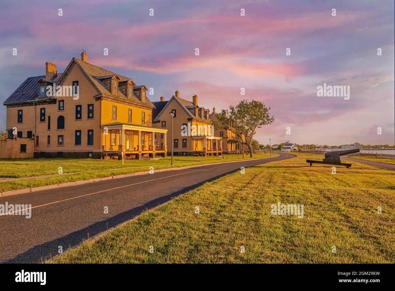 OUKers Row Fort Hancock NJ - il sole che tramonta accanto ai quartieri degli ufficiali a Fort Hancock su Sandy Hook New Jersey. Questa immagine è disponibile anche Foto Stock
