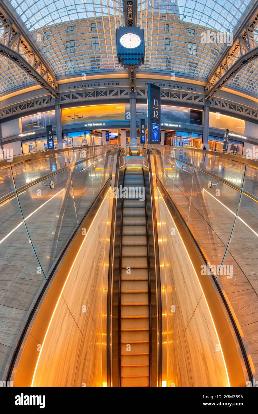 Moynihan Train Hall NYC - Vista scala mobile dorata della stazione ferroviaria recentemente rinnovata nel centro di Manhattan a New York City. Con le parole e pluribus Foto Stock