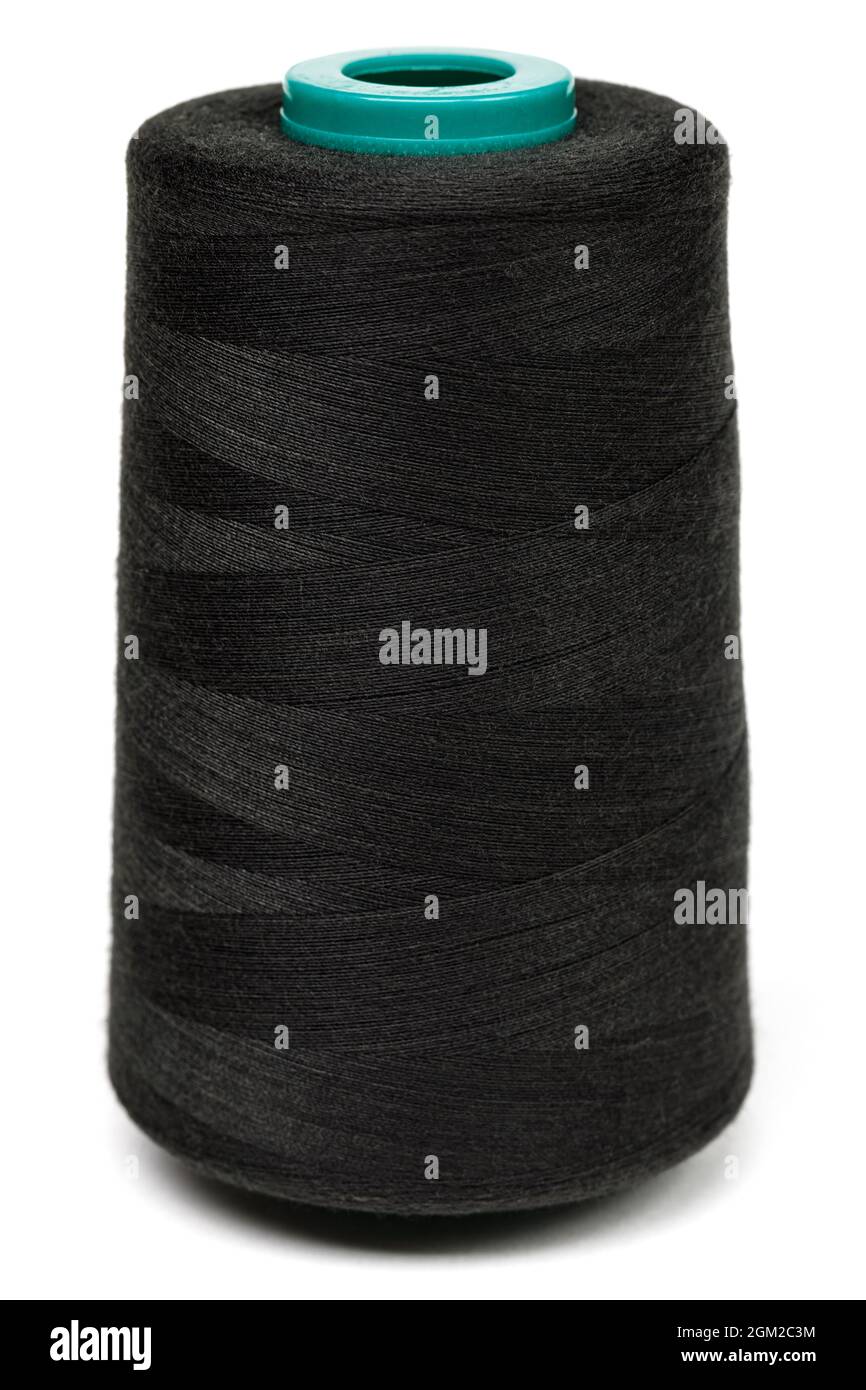 Rocchetto di fili neri sintetici o di cotone isolato su sfondo bianco. Bobina di filato utilizzata per la tessitura nella produzione tessile Foto Stock