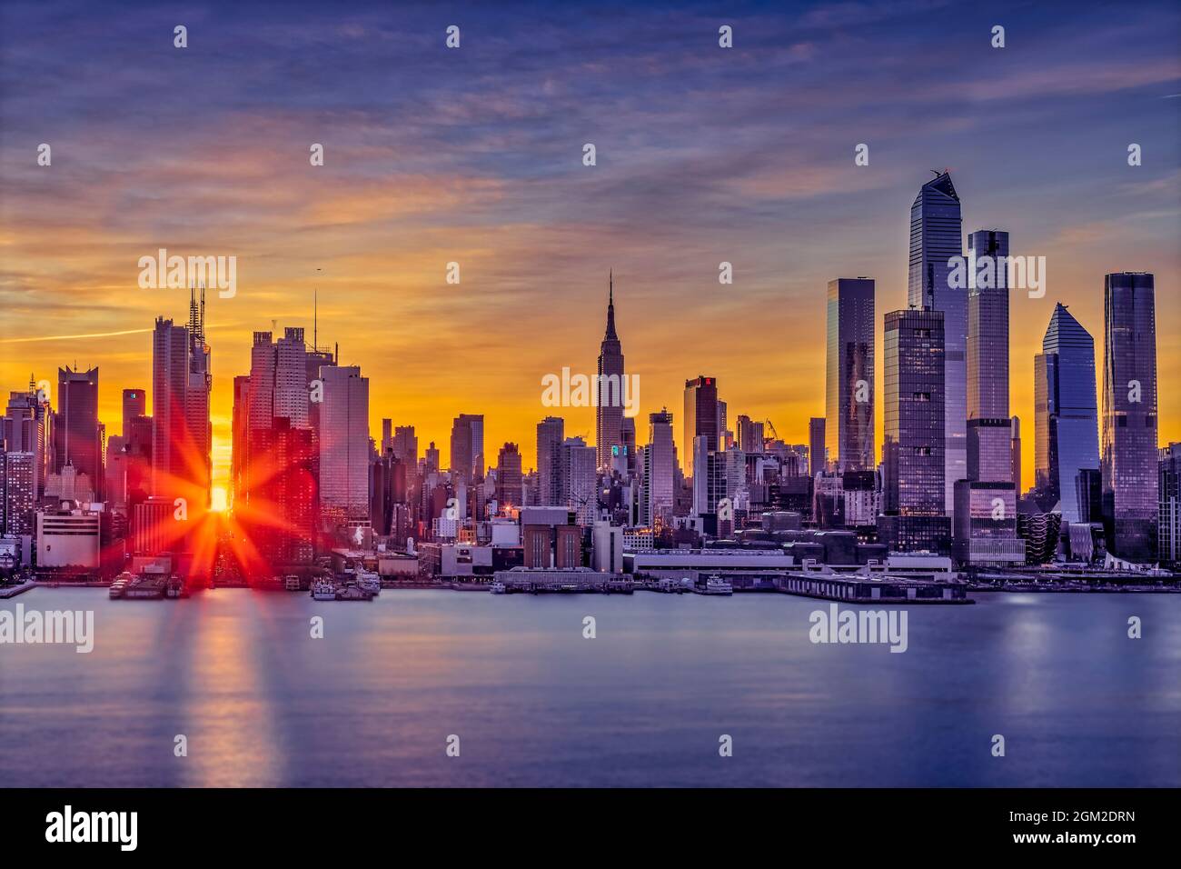 NYC Manhattanhenge - Manhattan 42nd Street Times Square NYC Winter Solstice Manhattanhenge. Quando il sole sorge e si allinea con le strade est-ovest di Foto Stock