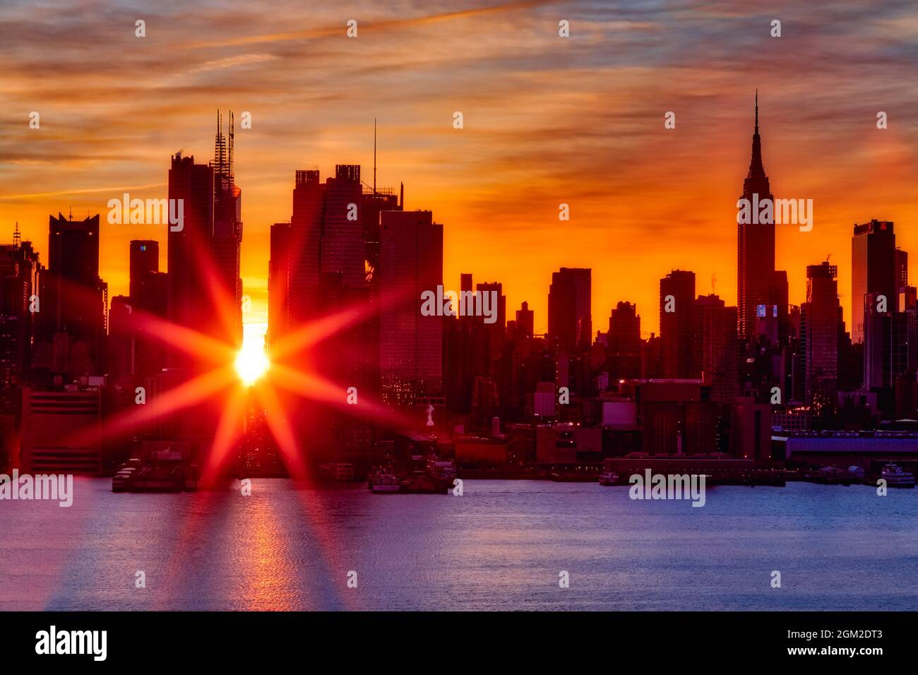 Manhattanhenge NYC - Manhattan 42nd Street Times Square NYC Winter Solstice Manhattanhenge. Come il sole sorge e si allinea con le strade est-ovest o Foto Stock