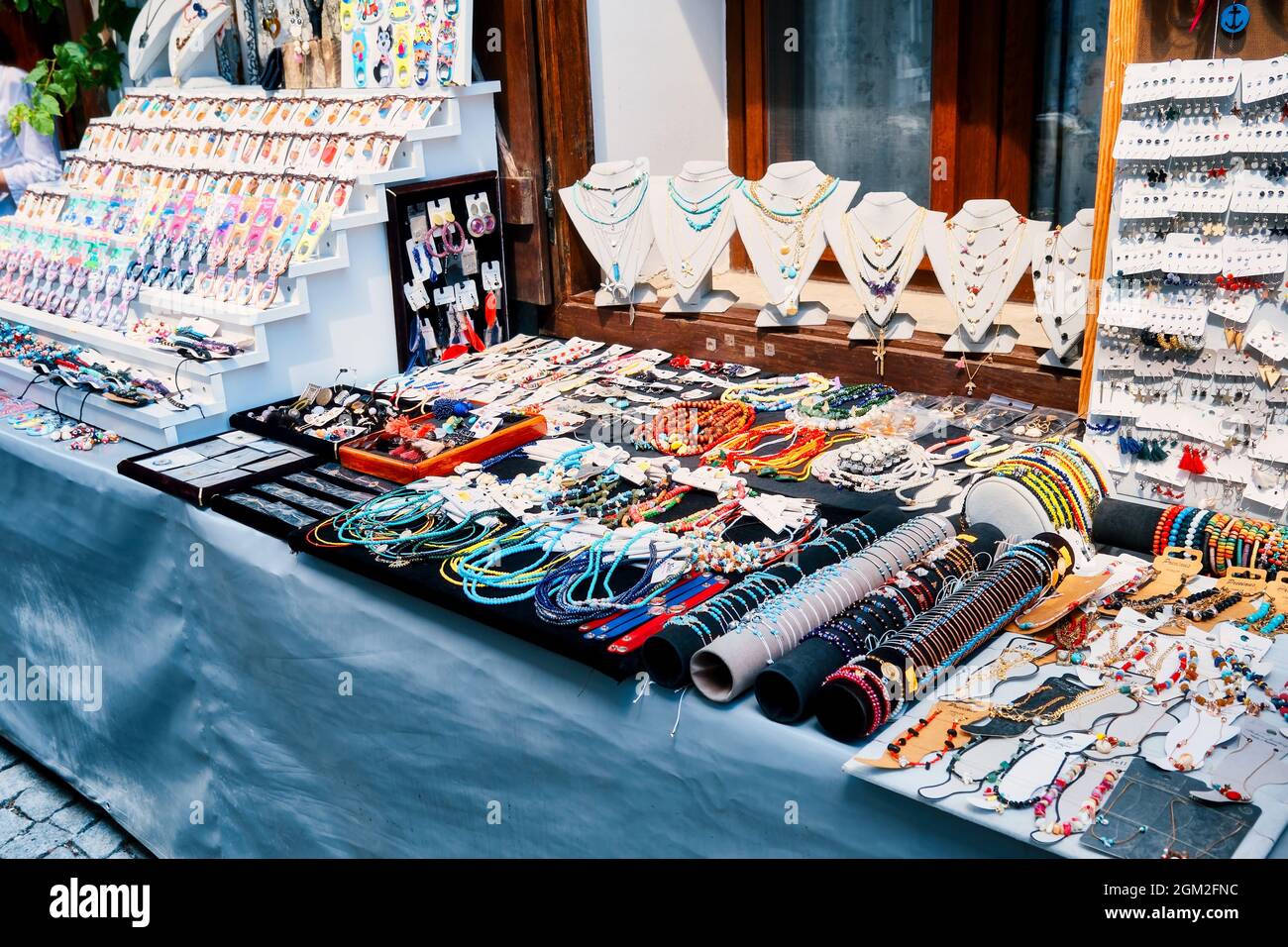 Giugno, 2021 - Seferihisar, Izmir, Turchia: Negozio di souvenir con uno stand all'aperto sulla strada con autentici bigiotteria fatti a mano e gioielli in vendita Foto Stock