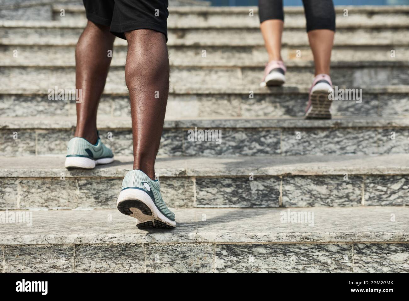 Primo piano dei giovani in scarpe sportive che si muovono sulle scale mentre si allenano all'aperto Foto Stock