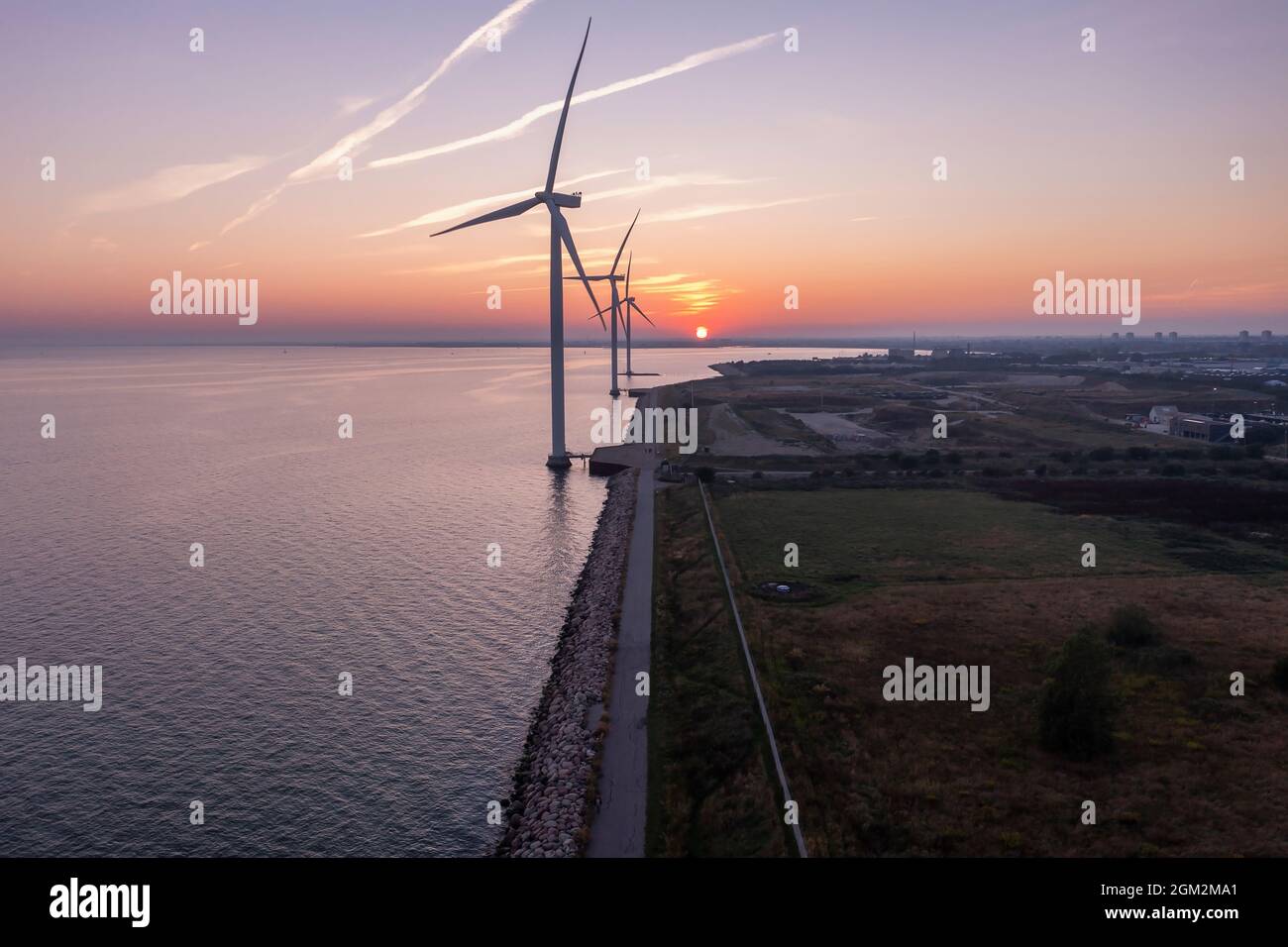 Turbine eoliche al tramonto. Produzione di energia ecologica. Foto Stock