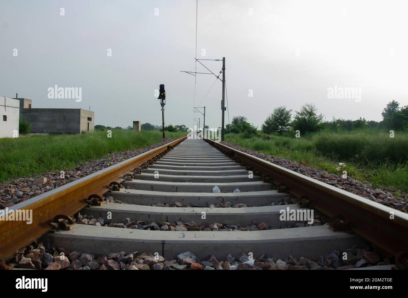 BINARIO FERROVIARIO CON LUCE E POLO ELETTRICO IN PAESAGGIO. PISTA FERROVIARIA INDIANA AL MATTINO ALLA LUCE DEL SOLE. Foto Stock