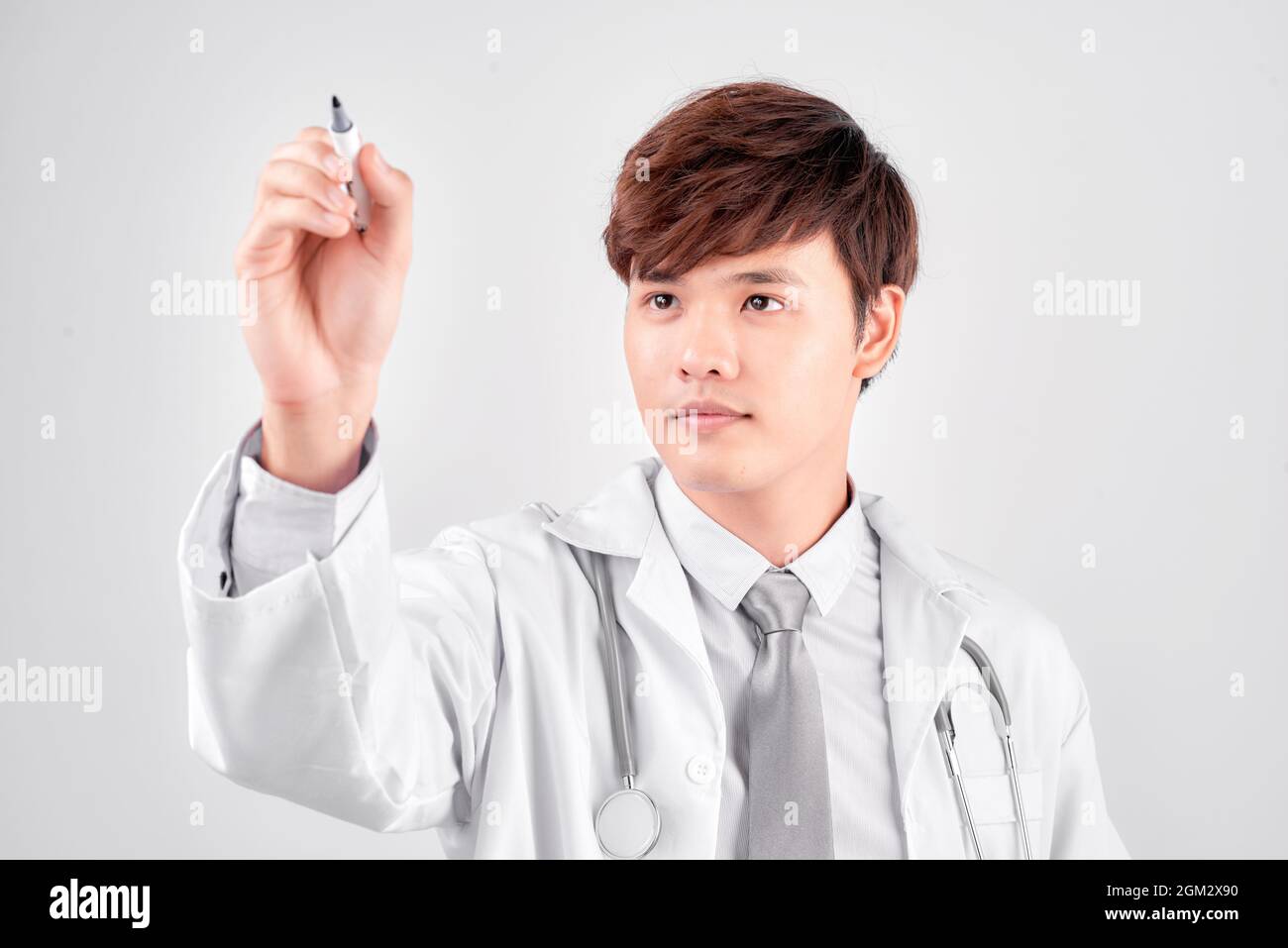 medico senior isolato in uniforme medica scrittura in aria Foto Stock