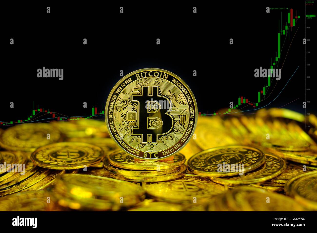 Criptocurrenza del bitcoin d'oro su pila moneta d'oro su sfondo di tabella di scambio Foto Stock