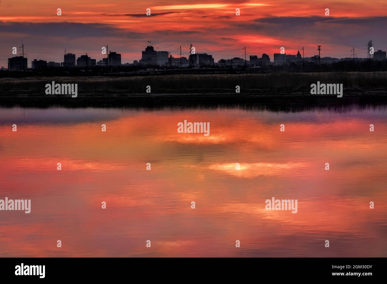 Newark New Jersey Skyline - Vista Silohuetted dello skyline della città di Newark con gli splendidi colori del sole che tramonta nell'Hackensack Ri Foto Stock