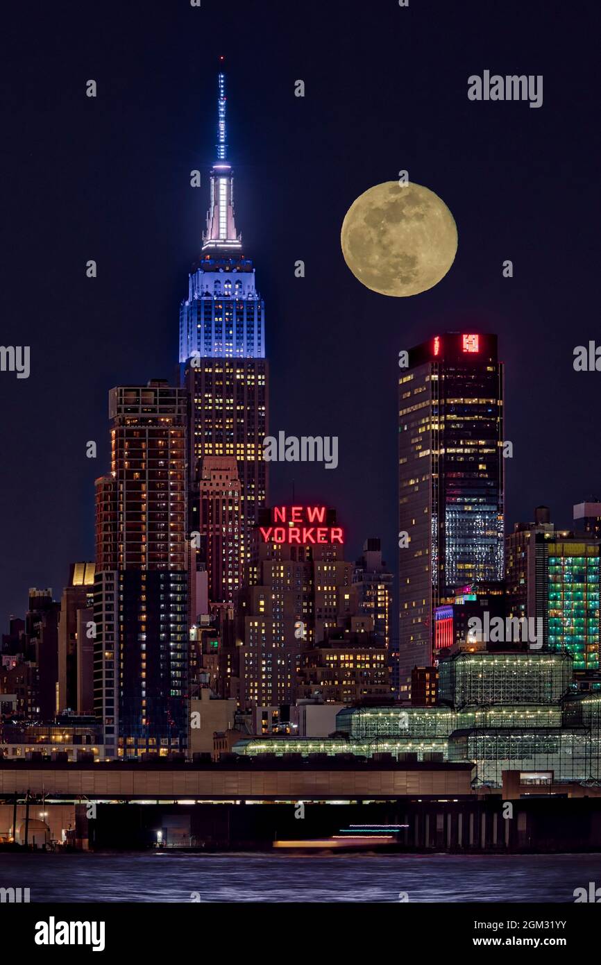 Empire state ESB Super Moon NYC - Vista dell'iconico punto di riferimento urbano dell'Empire state Building illuminato in bianco e blu. Si vede anche il newyorkese Foto Stock