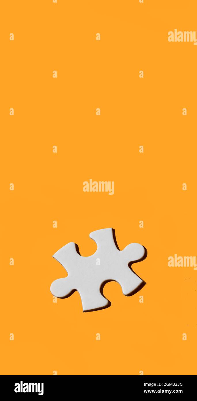 un pezzo di puzzle bianco su sfondo giallo orangeo, in un formato verticale  panoramico da utilizzare per le storie mobili o come sfondo per smartphone  Foto stock - Alamy