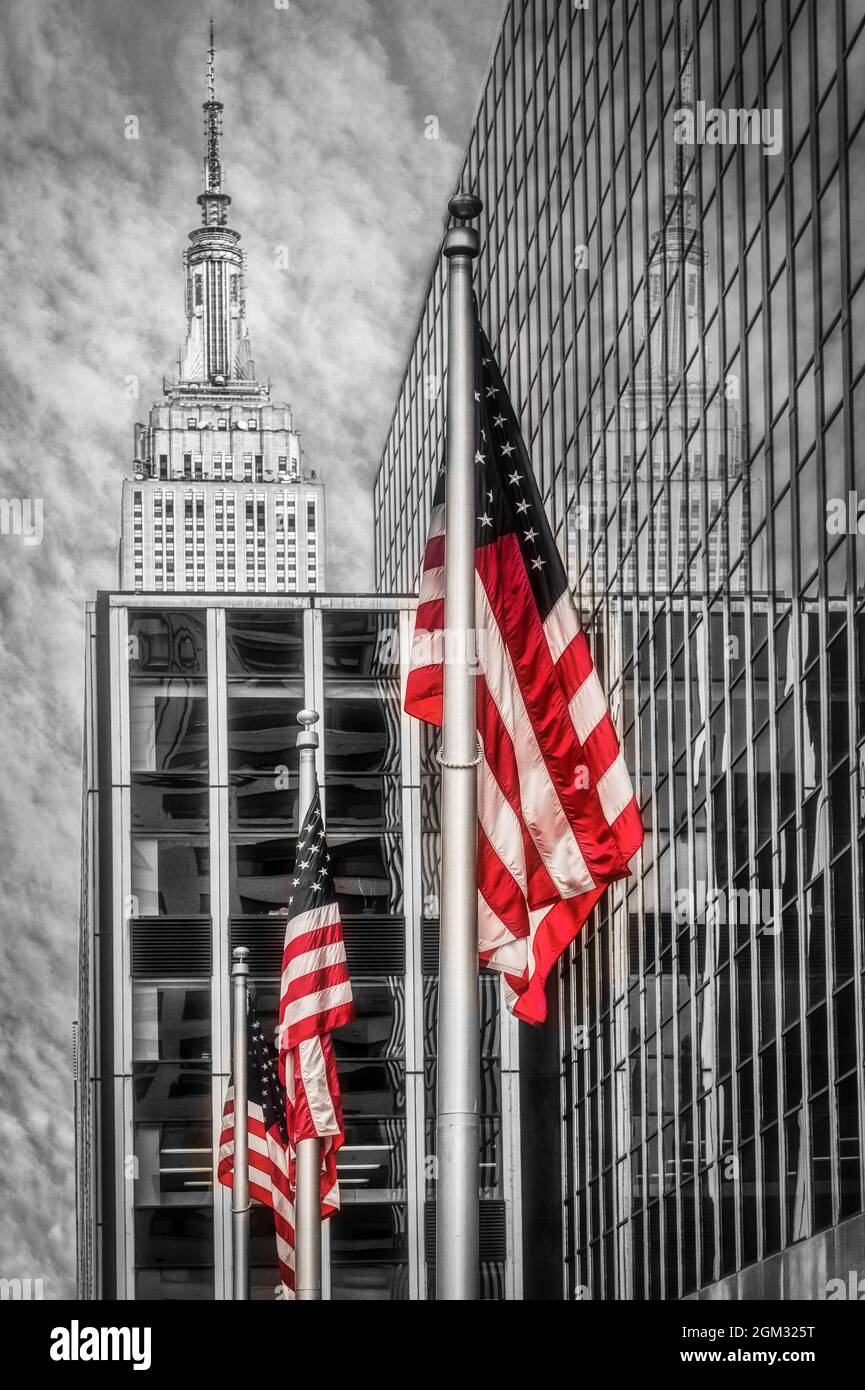 Empire state NYC Reflections - Trio di bandiere americane volano sotto la cima dell'Empire state Building nel centro di Manhattan, New York City. L'iconico Foto Stock