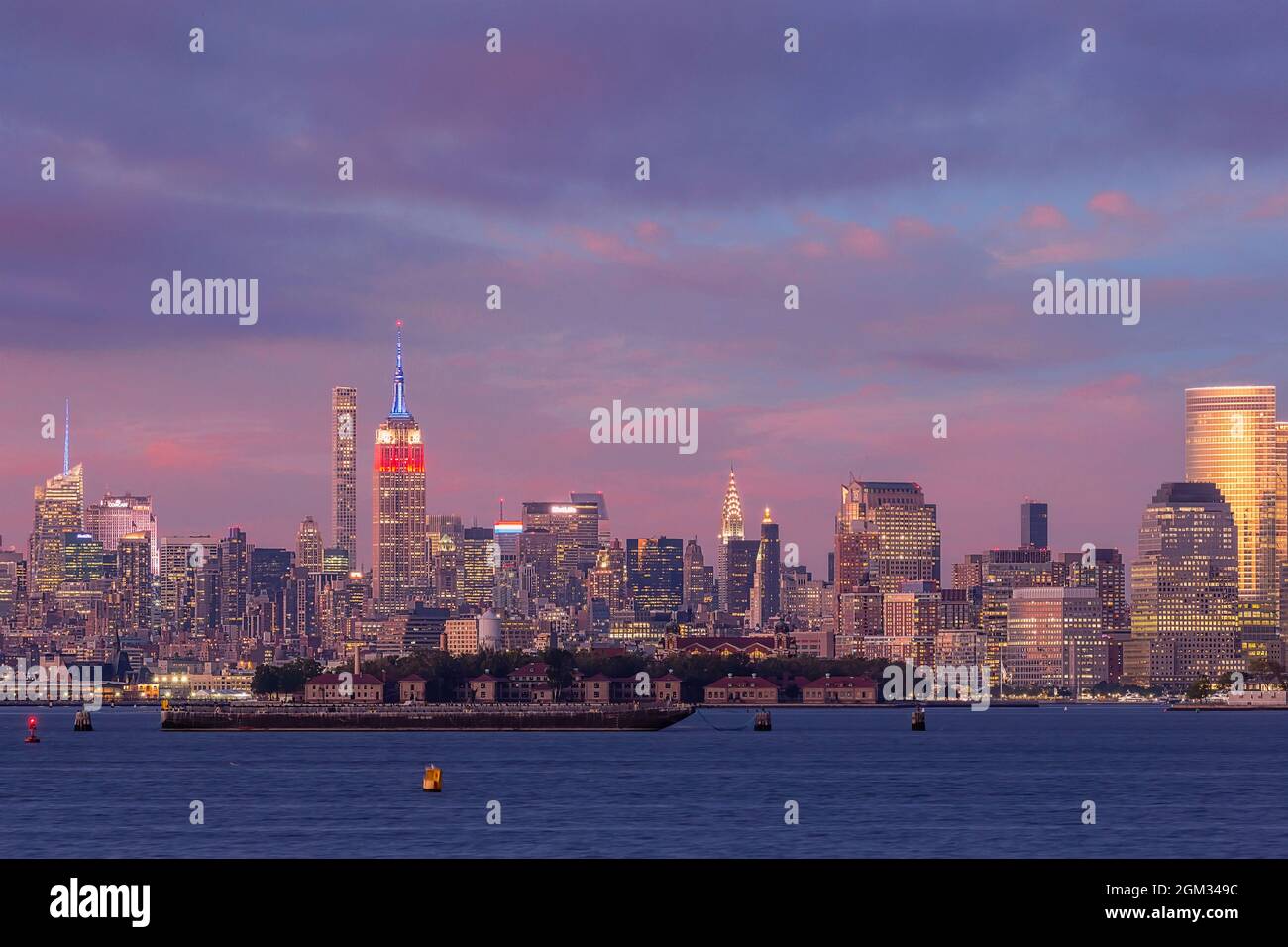 Icone di New York City - lo skyline di New York City dal centro di Lower Manhattan. Tra le tante viste si trova l'Empire state Building (ESB) illuminato in r Foto Stock