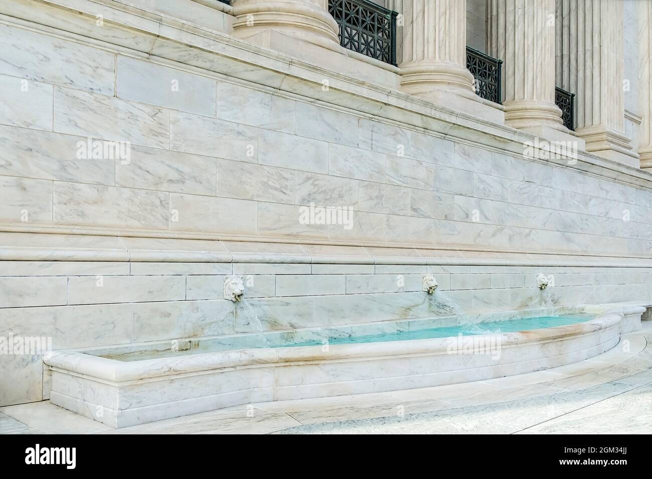 Le teste dei leoni servono come beccucci per l'acqua in questa fontana presso il Palazzo della Corte Suprema. Foto Stock