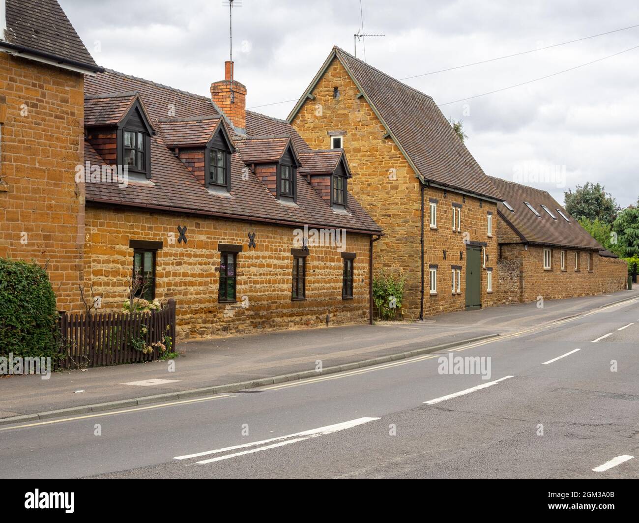 Scena stradale con tradizionali cottage in pietra nel villaggio di Duston, Northampton, Regno Unito Foto Stock