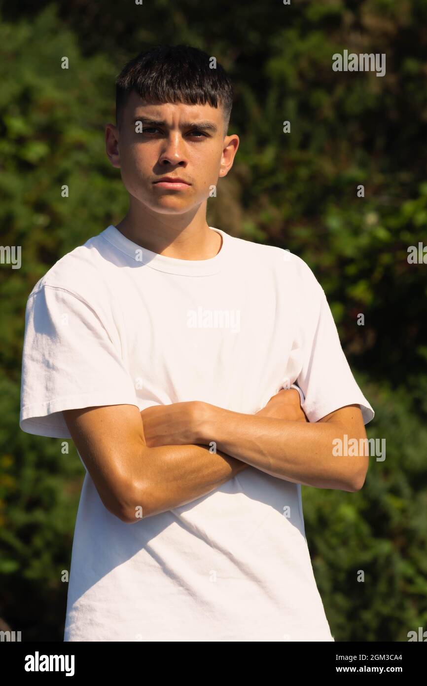 ragazzo di 18 anni in una t-shirt bianca all'aperto con braccia ripiegate  Foto stock - Alamy