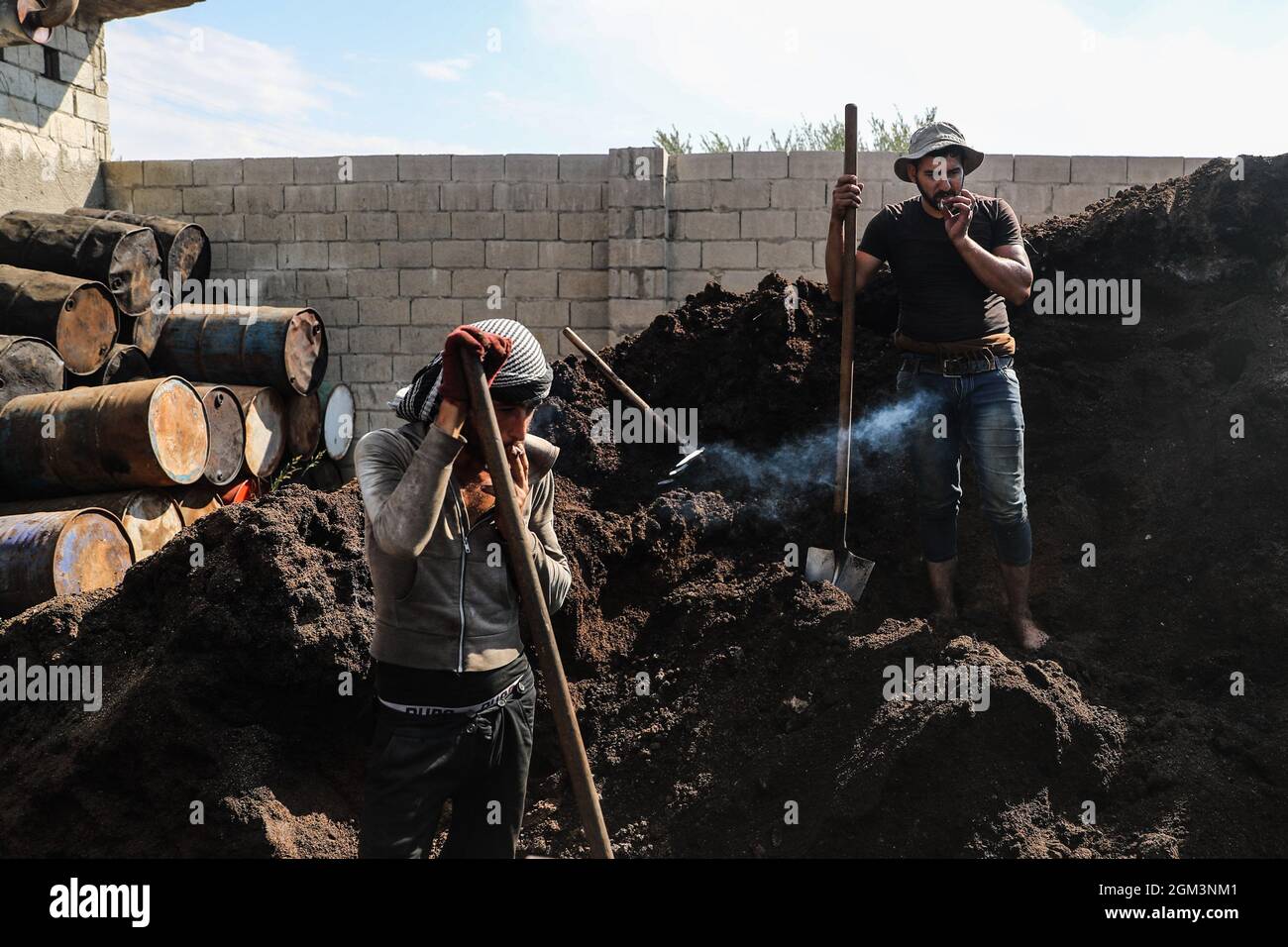 Armanaz, Siria. 16 settembre 2021. I lavoratori siriani raccolgono i rifiuti di olio d’oliva in un impianto di pressatura che trasforma i rifiuti in combustibile. L'impianto sta trasformando l'acqua di olio d'oliva in combustibile, con l'aumento dei prezzi del petrolio nel paese lacerato dalla guerra prima dell'inverno. Credit: ANAS Alkharboutli/dpa/Alamy Live News Foto Stock