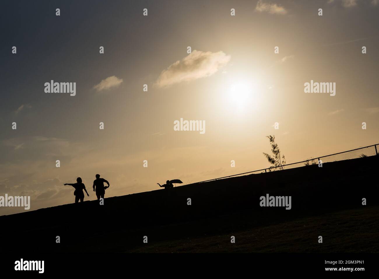 Immagine di stile di vita di due persone che si trovano in piedi insieme con una che punta il dito verso l'alto durante il tramonto a San Juan, Porto Rico. Toni caldi Foto Stock
