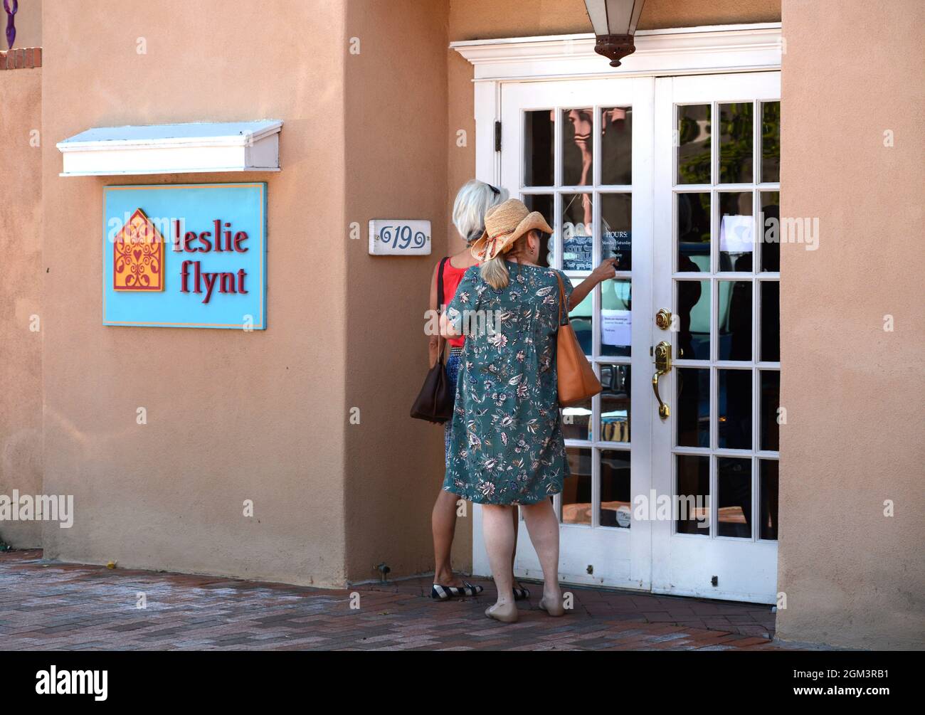 Due donne turisti si preparano ad entrare in una galleria d'arte a Santa Fe, New Mexico. Foto Stock