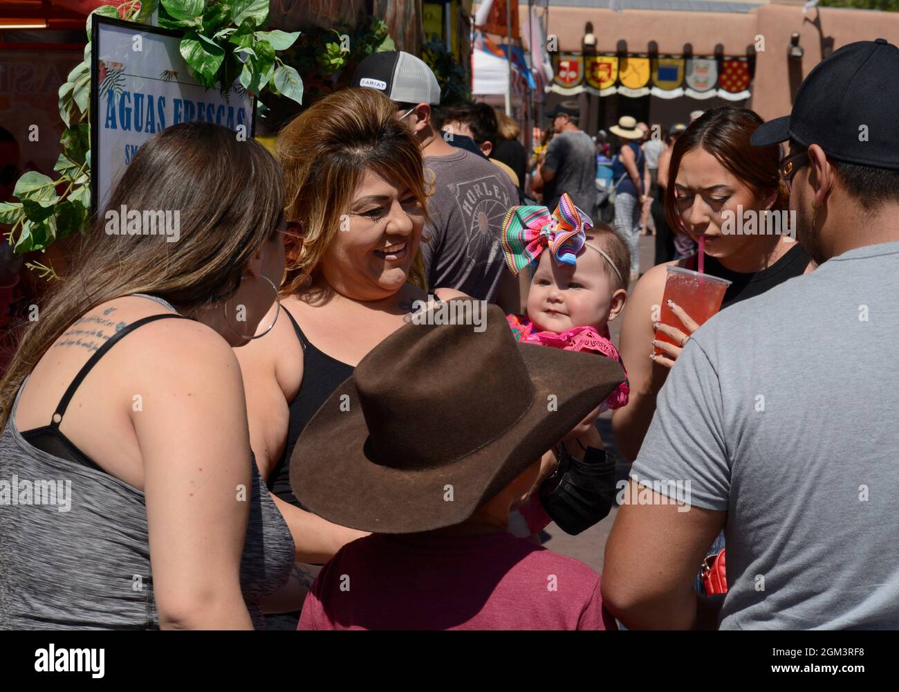 Una donna mostra il suo bambino giovane agli amici durante il festival annuale di Fiesta ispanica a Santa Fe, New Mexico. Foto Stock