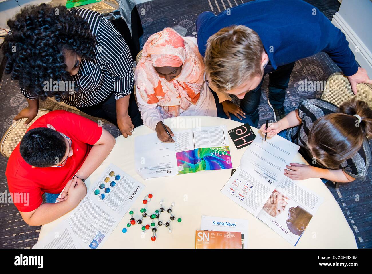 I bambini in età scolastica fanno insieme un'esperienza scientifica Foto Stock