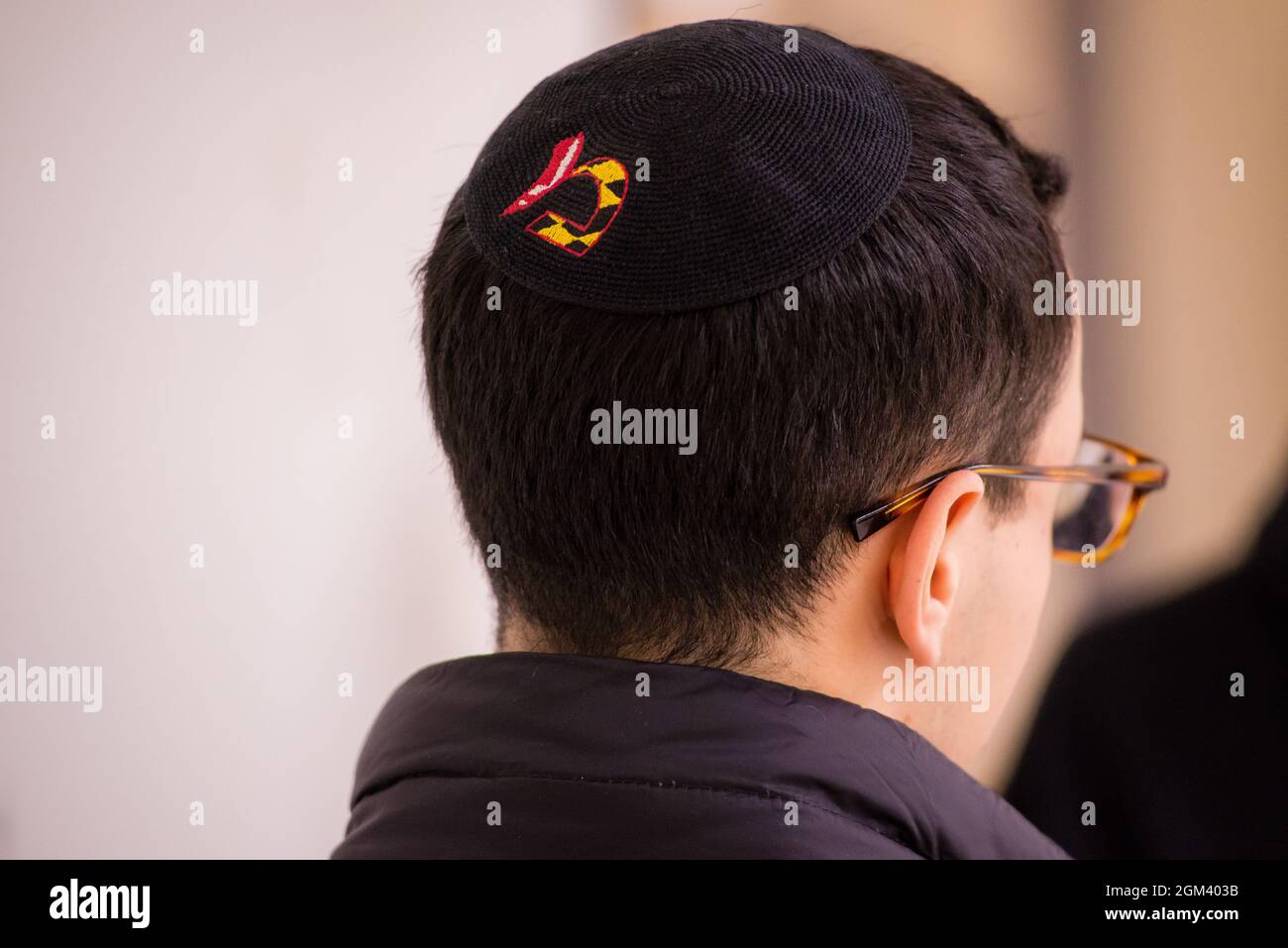 Giovane uomo che indossa un yarmulke e occhiali dalla parte posteriore. Foto Stock