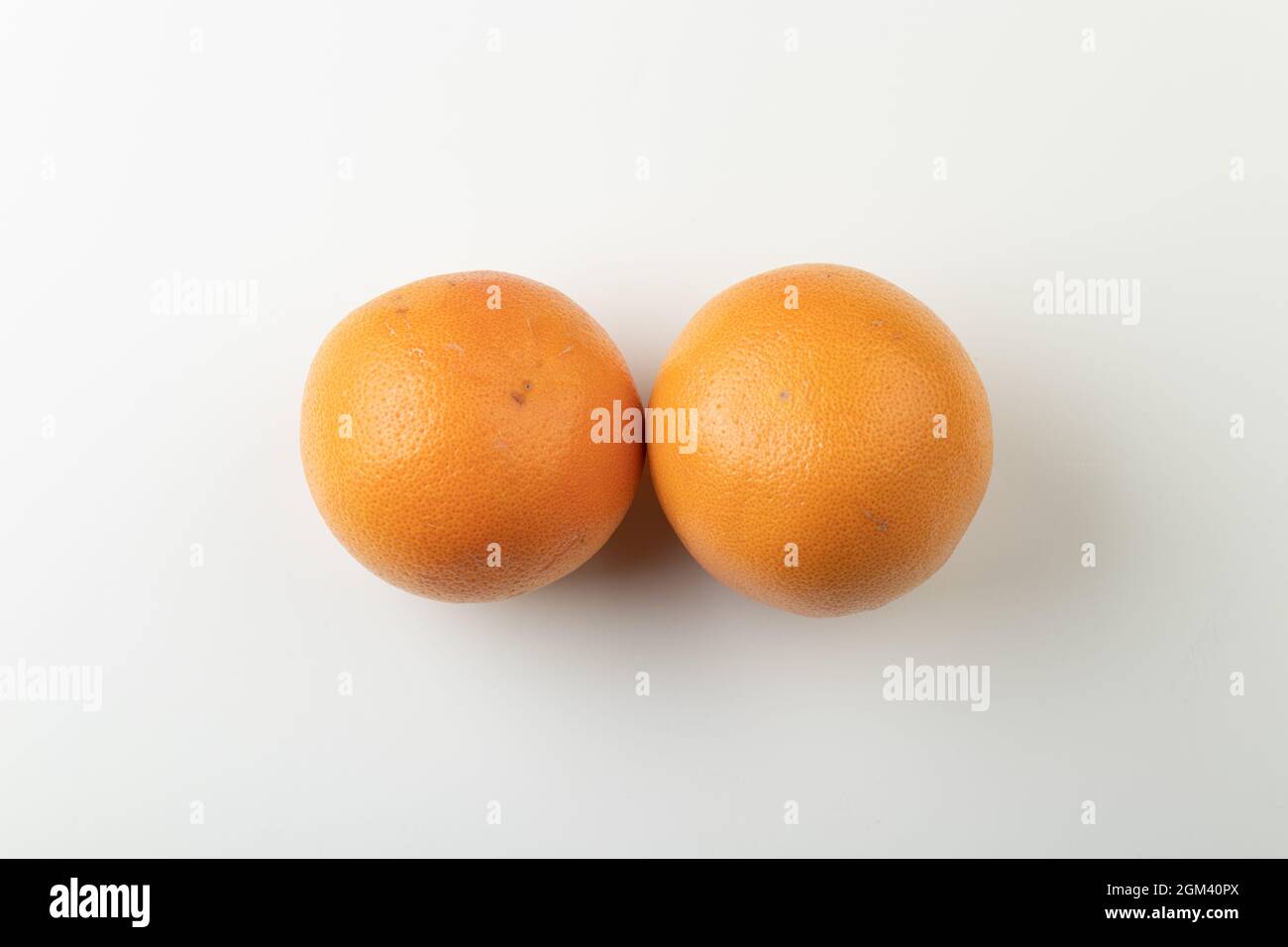 Due pompelmi arancioni interi isolati su sfondo bianco, vista dall'alto Foto Stock