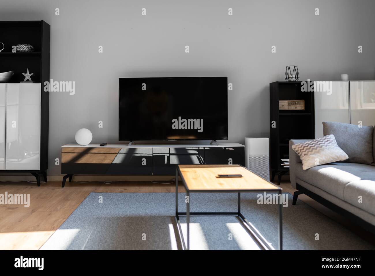 Mobili TV interni in soggiorno con pavimento in legno Foto Stock