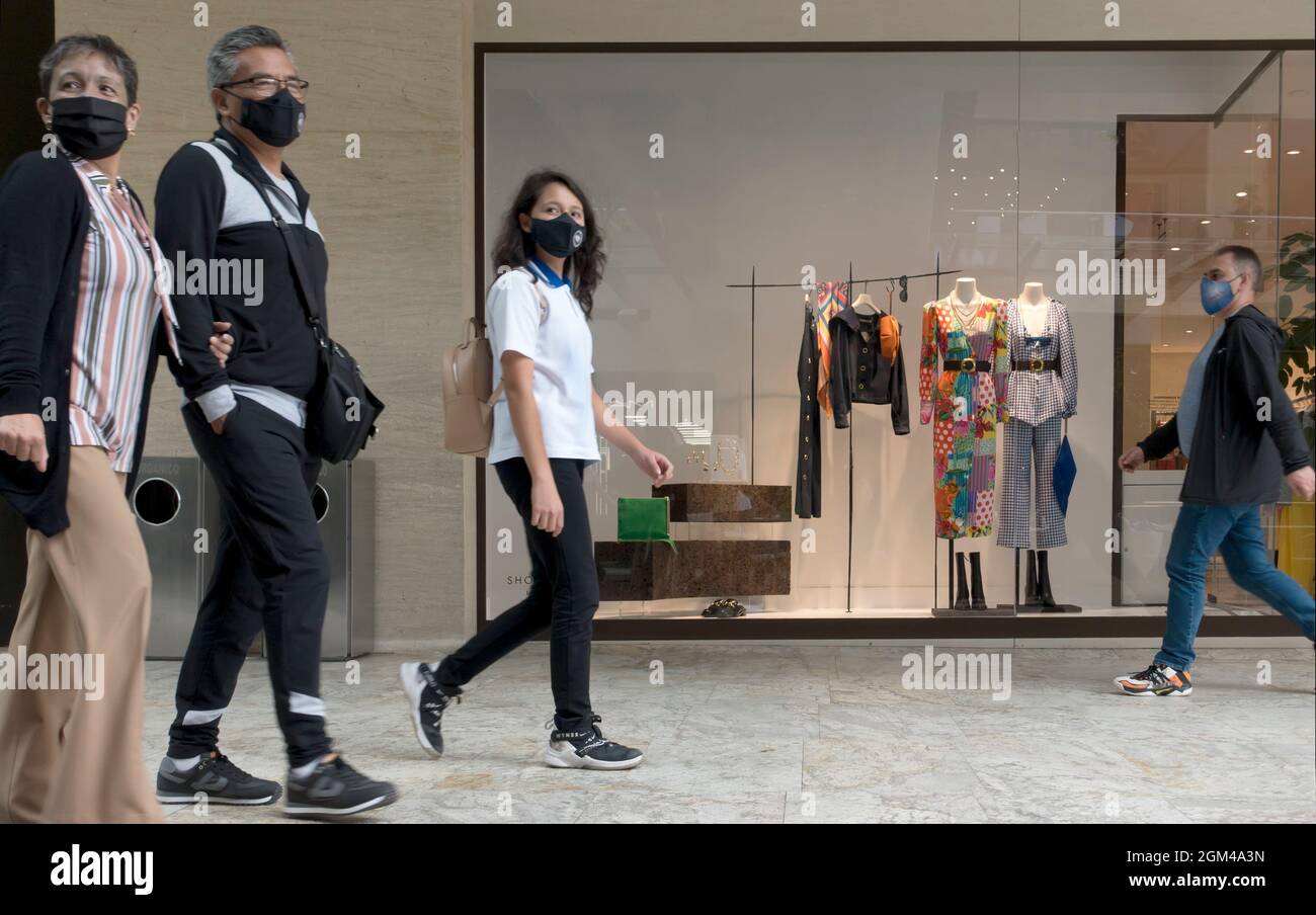 Persone che indossano maschere in un centro commerciale durante la pandemia di Covid-19 Foto Stock