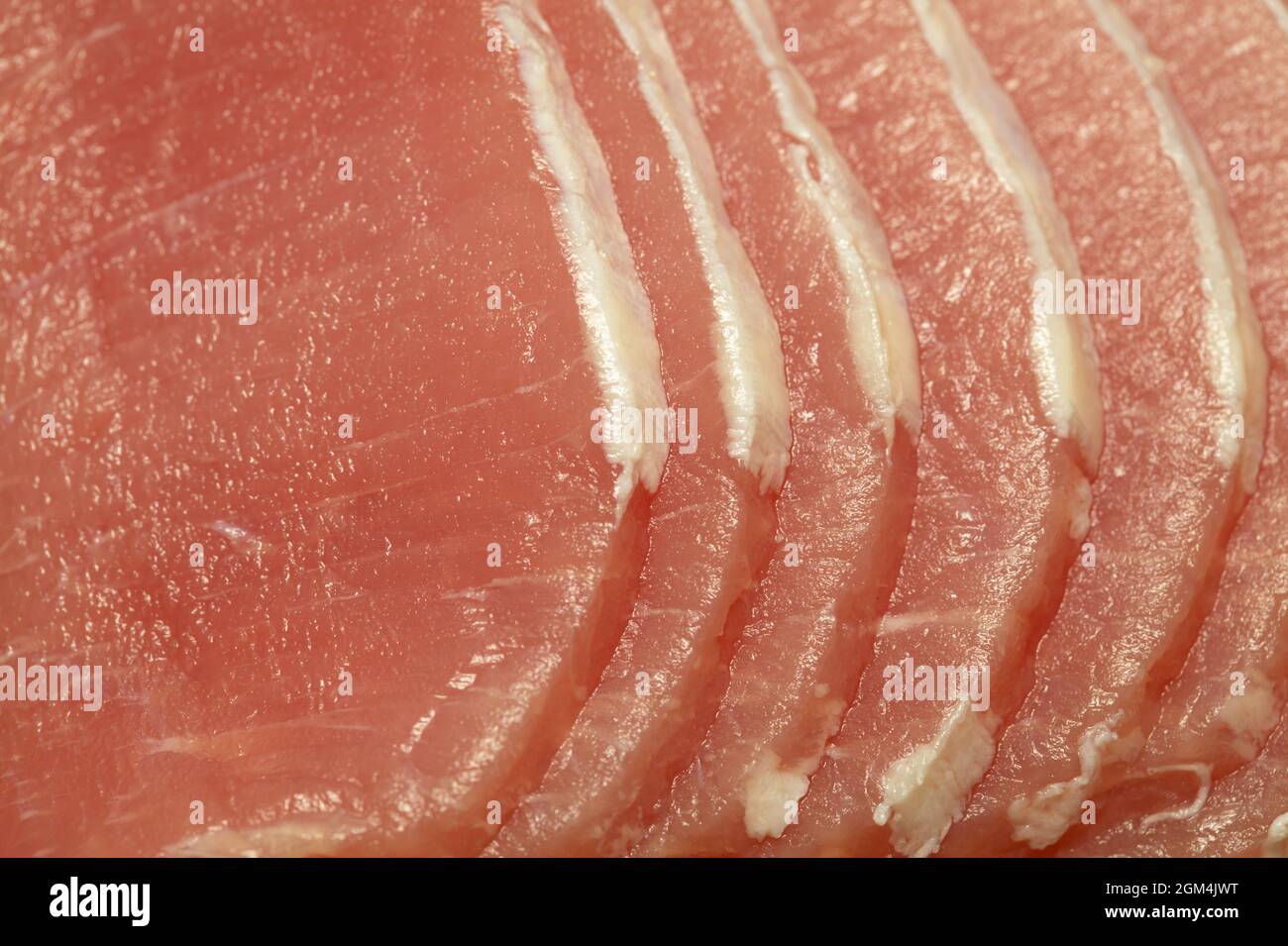 Lombata magra di maiale marinata cruda tagliata a fette sottili con quasi tutto il grasso rifinito Foto Stock