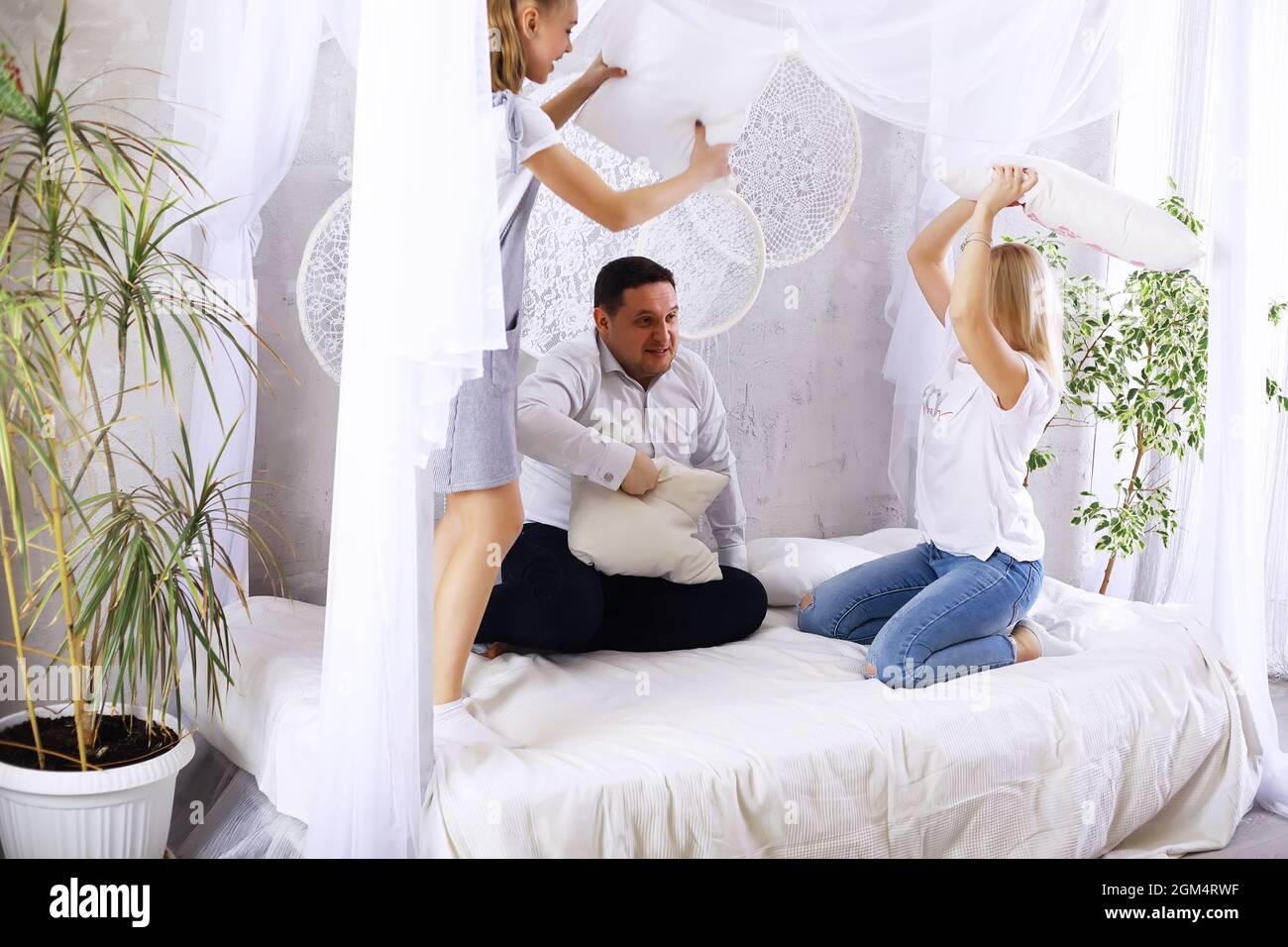 Divertente famiglia attiva di giovani genitori adulti e bambini piccoli carini che giocano insieme nel soggiorno interno, spensierati bambini piccoli con mamma papà che hanno Foto Stock