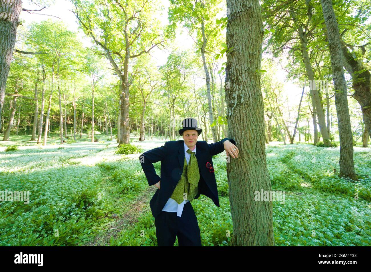 L'uomo bianco in un vestito ed il cappello del cilindro è appoggiato contro  un albero in Foto stock - Alamy