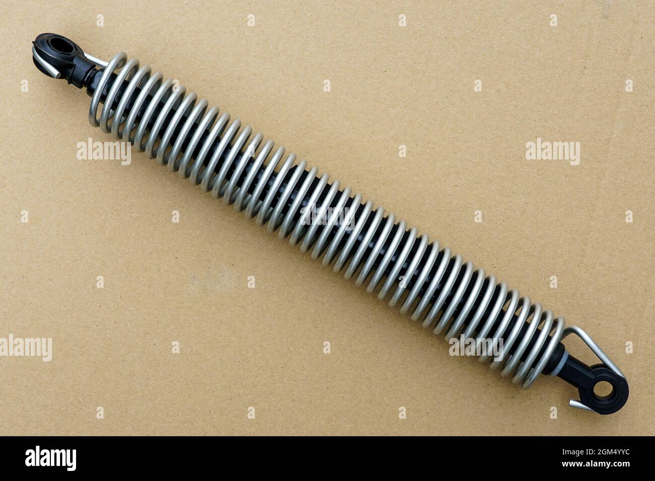 ammortizzatore del cofano e dello sportello del bagagliaio con molla esterna su sfondo di cartone Foto Stock