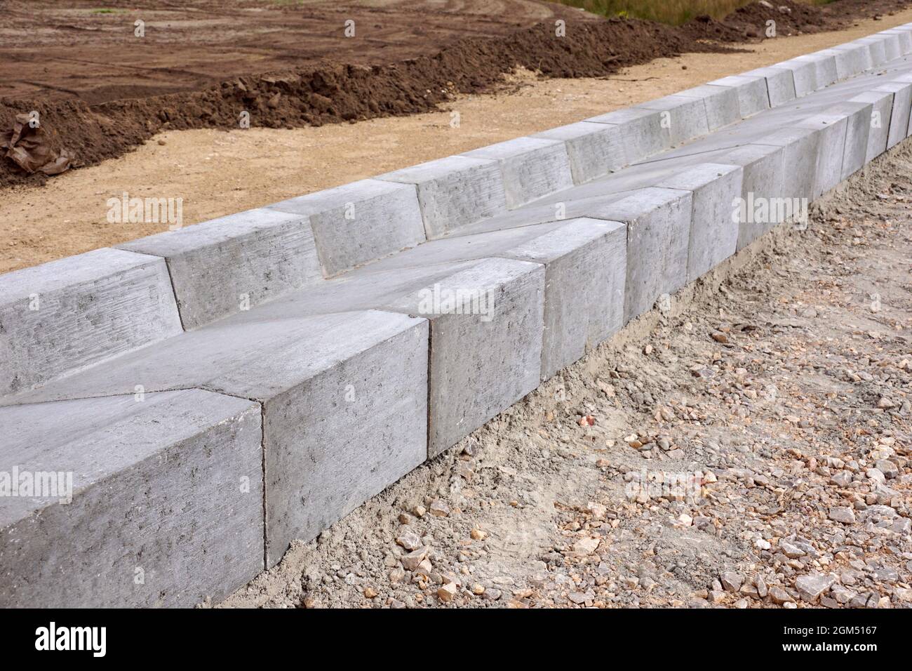 Un sistema di moduli in calcestruzzo per lo scarico dell'acqua in eccesso dal manto stradale. Costruzione dell'autostrada. Foto Stock