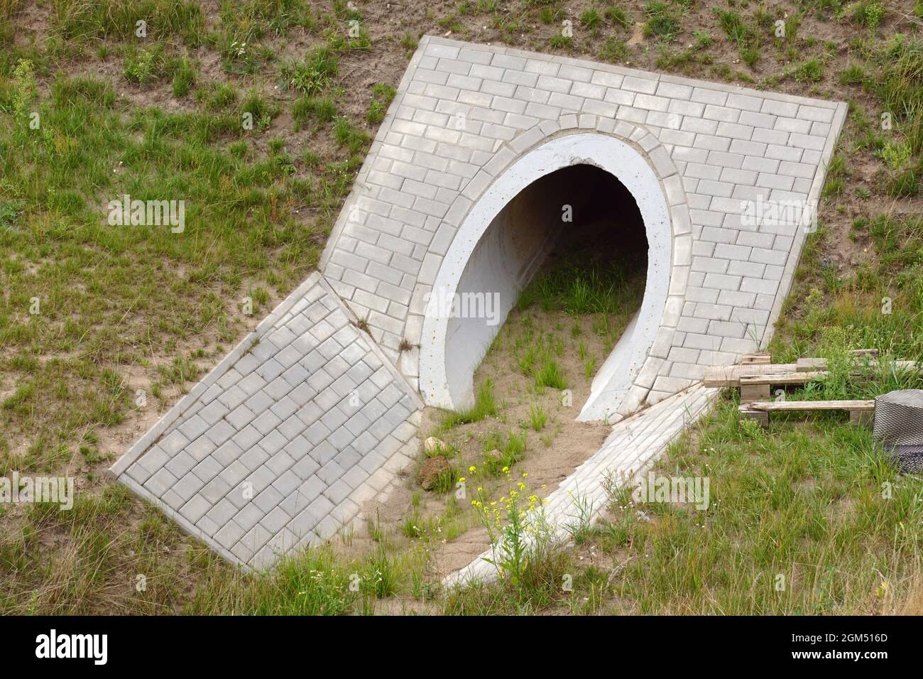 L'uscita del canale di calcestruzzo che scarica l'acqua in eccesso dalla strada. Costruzione dell'autostrada. Foto Stock