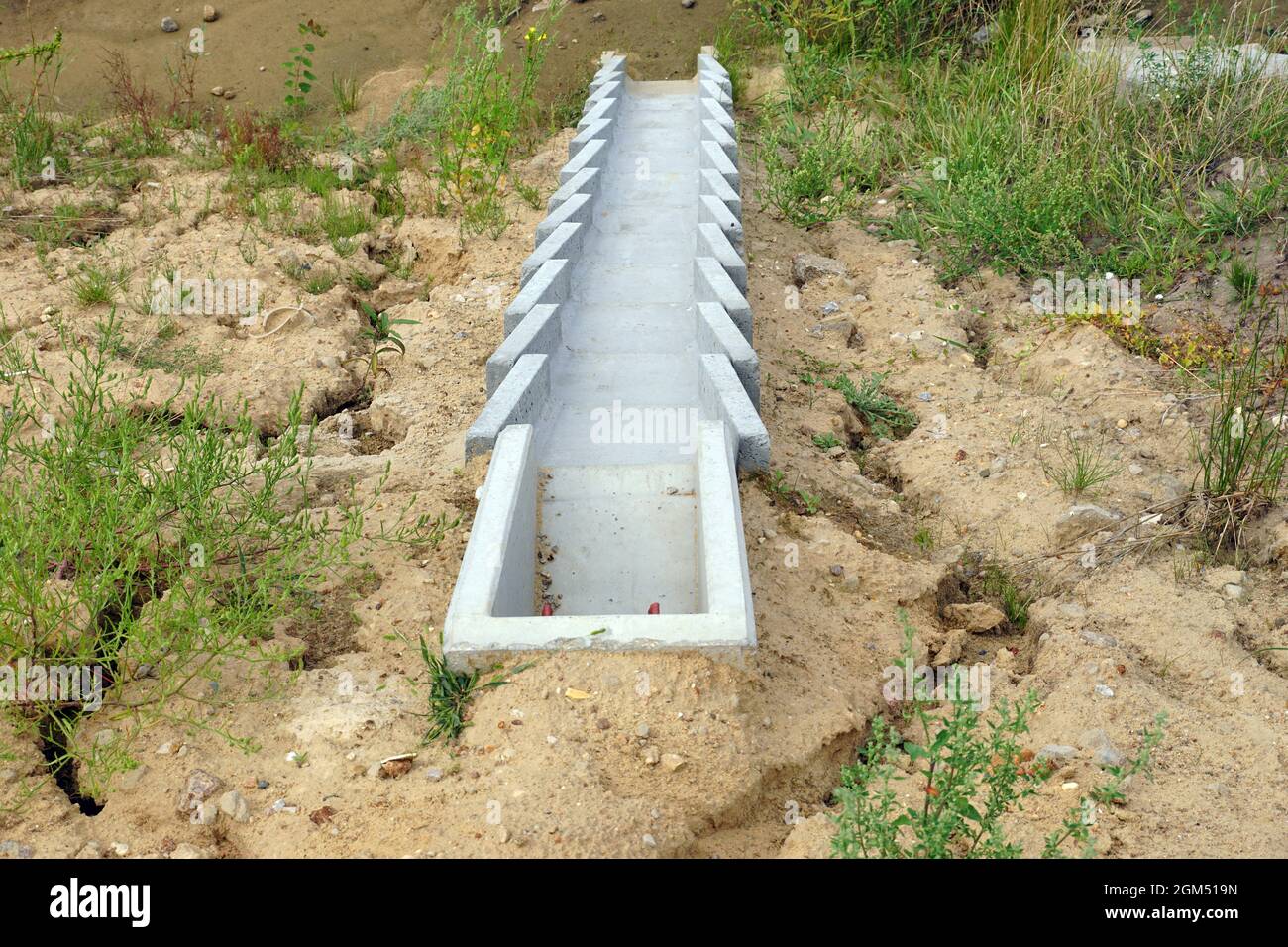 Costruzione dell'autostrada. Un sistema di moduli in calcestruzzo per lo scarico dell'acqua in eccesso dal manto stradale. Foto Stock