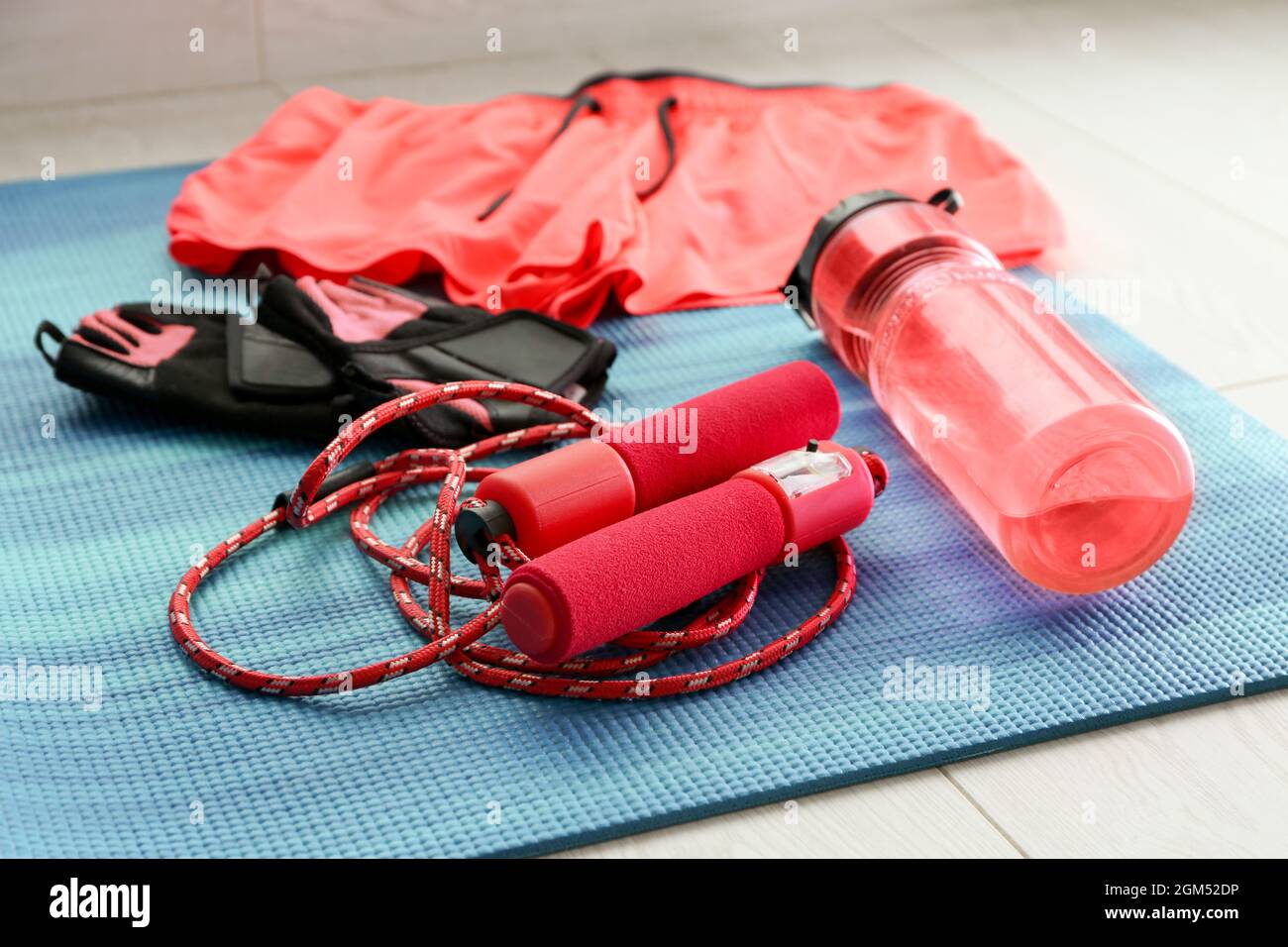 Corda per salto e bottiglia di plastica sul tappetino blu per yoga Foto  stock - Alamy
