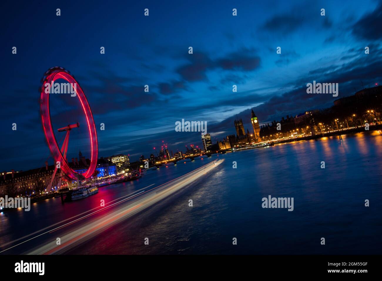 Londra al crepuscolo. London Eye, County Hall, Westminster Bridge, Big ben e Houses of Parliament. Lunga esposizione della ruota che gira con movimento da Foto Stock
