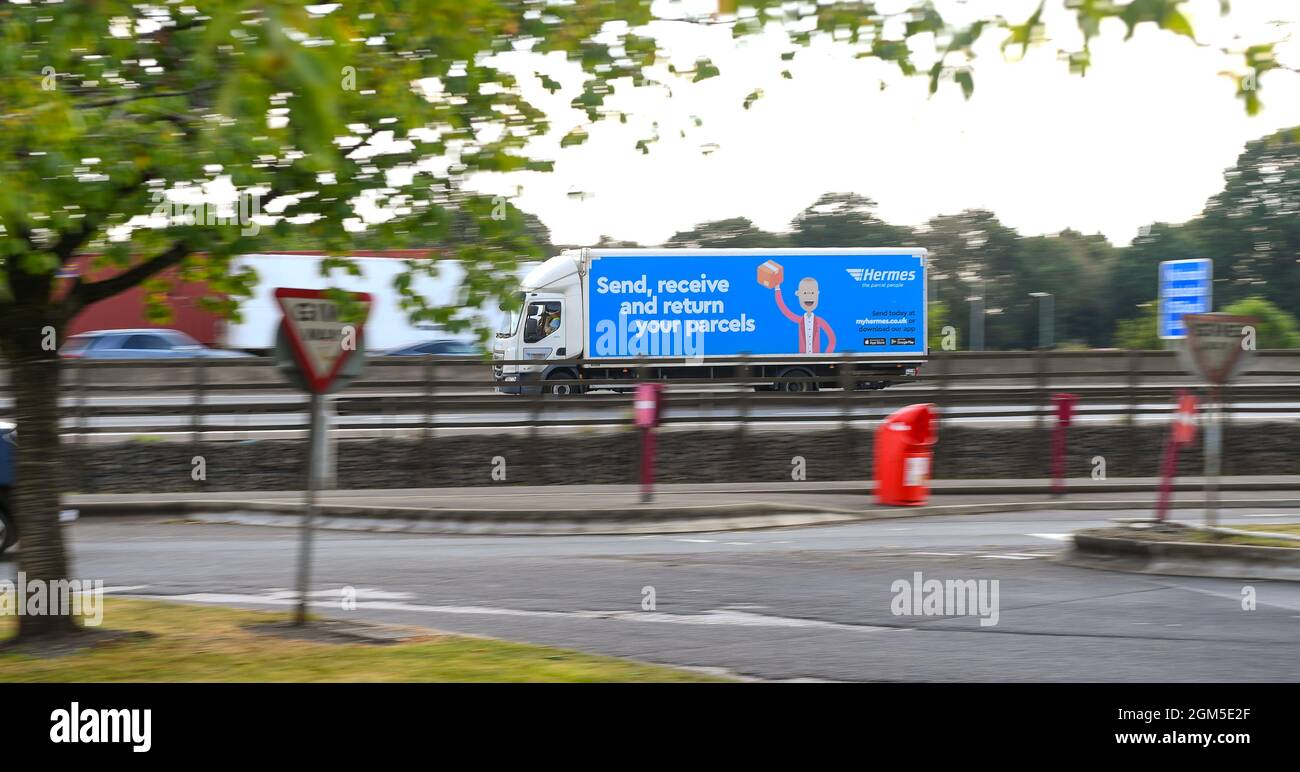 Un camion di consegna Hermes guida lungo l'autostrada M27 in una panoramica. Attualmente i conducenti di autocarri sono a corto di scorte che danneggiano la catena di approvvigionamento. Foto Stock
