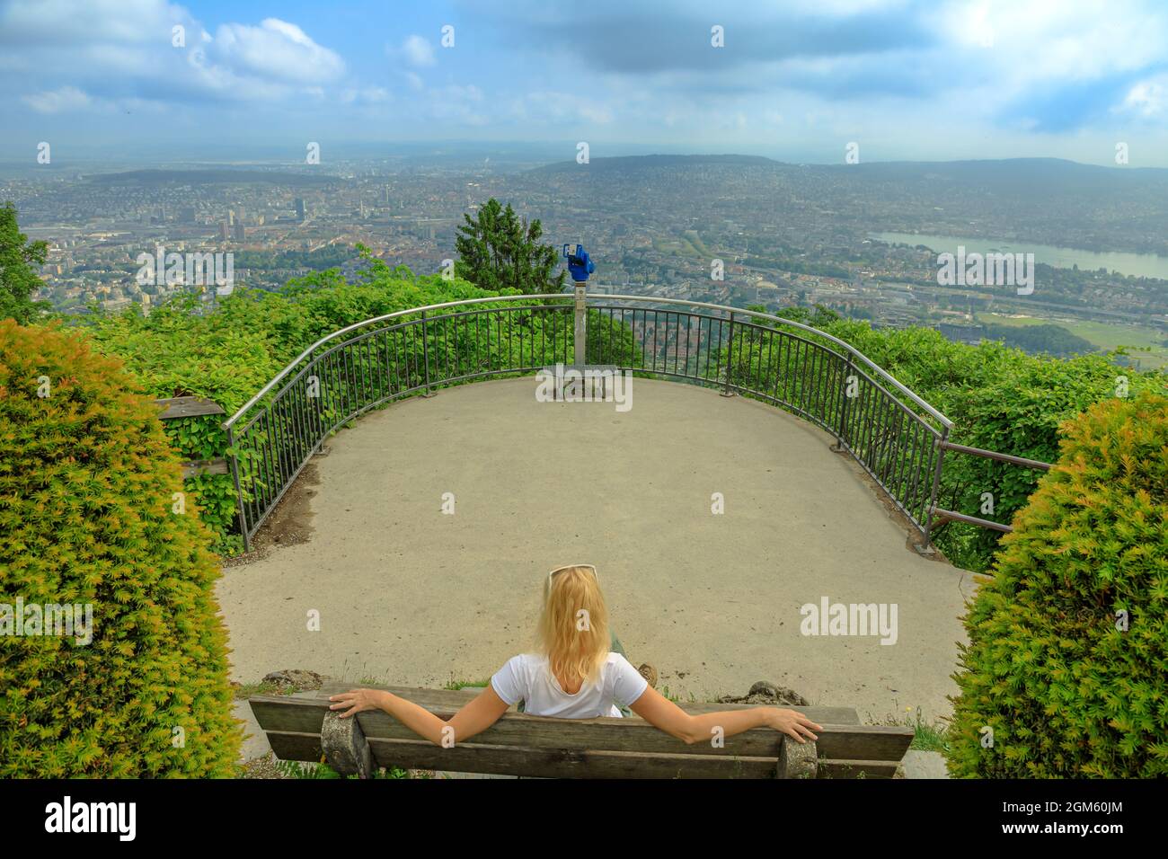 Donna seduta sul belvedere della montagna di Uetliberg. Skyline di Zurigo su uno svizzero sulla montagna di Uetliberg nell'altopiano svizzero in Svizzera. Ragazza spensierata con Foto Stock